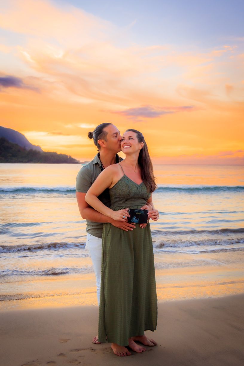 Romantic sunset beach photography session with warm orange sky over the ocean.