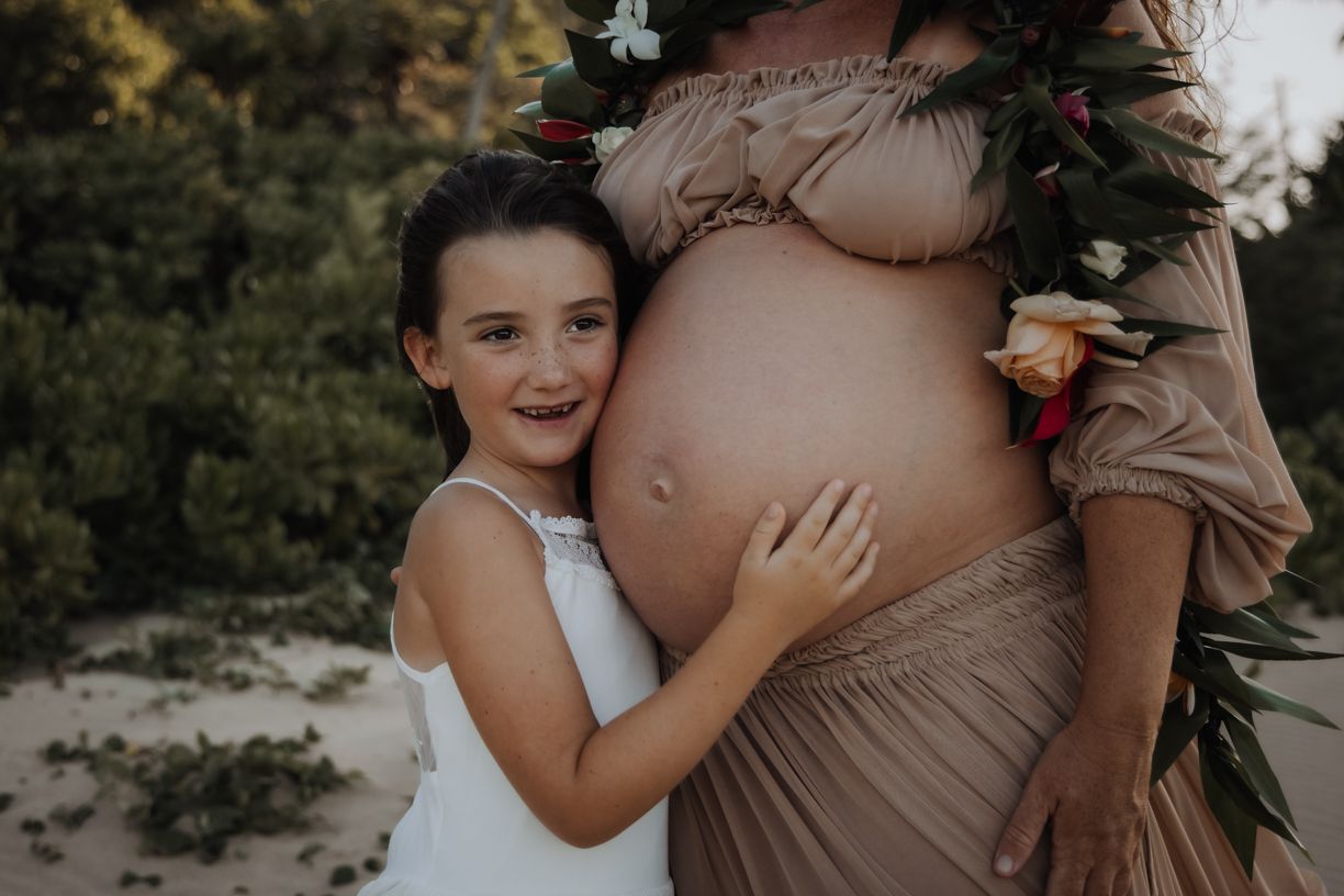 Close-up shots of young child hugging pregnant belly with joy and tenderness.
