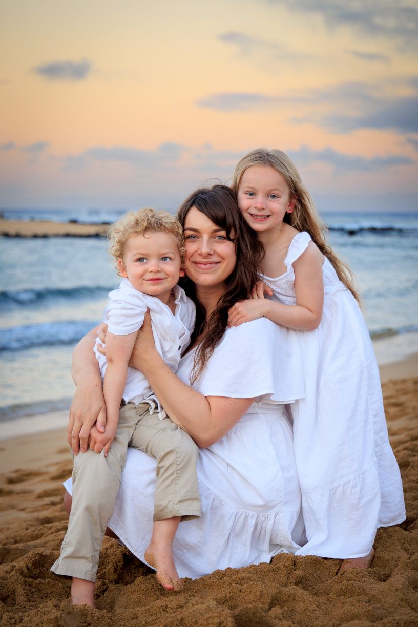 Casual beach portrait session with white clothing against ocean backdrop at sunset.