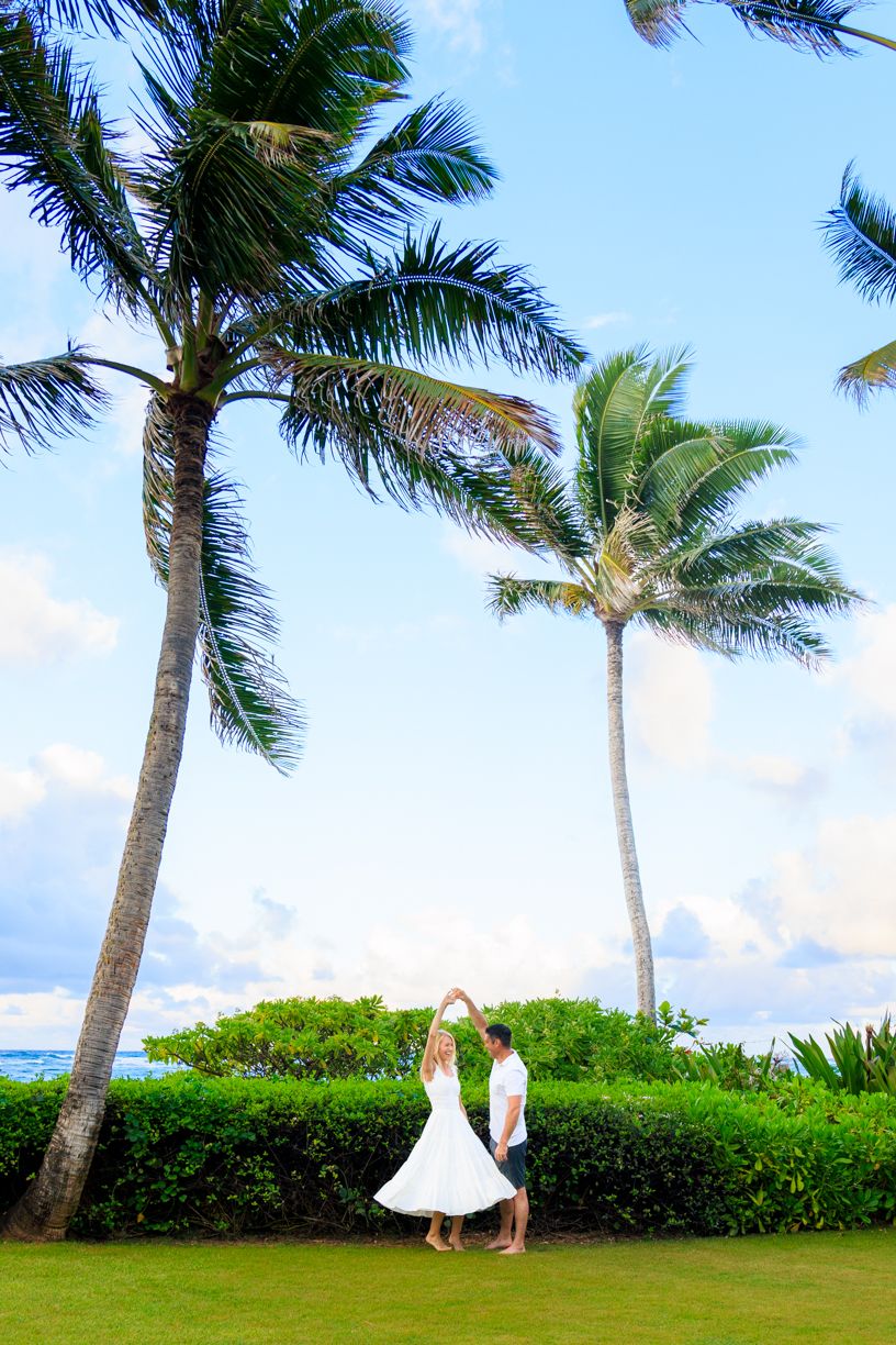 Palm trees sway in tropical breeze along oceanfront garden path.