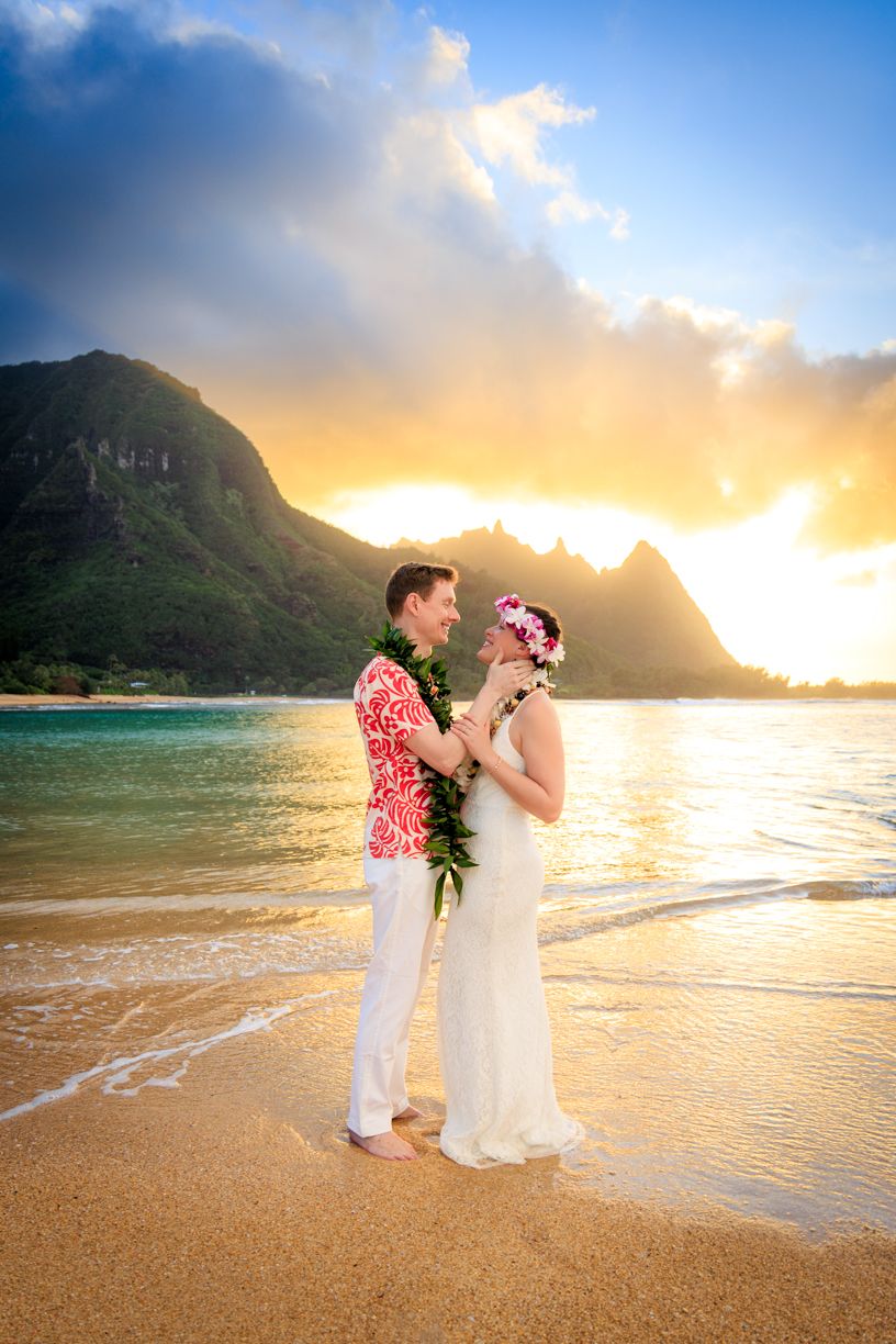 Romantic beach wedding photography session during a vibrant Hawaiian sunset at Tunnels Beach
