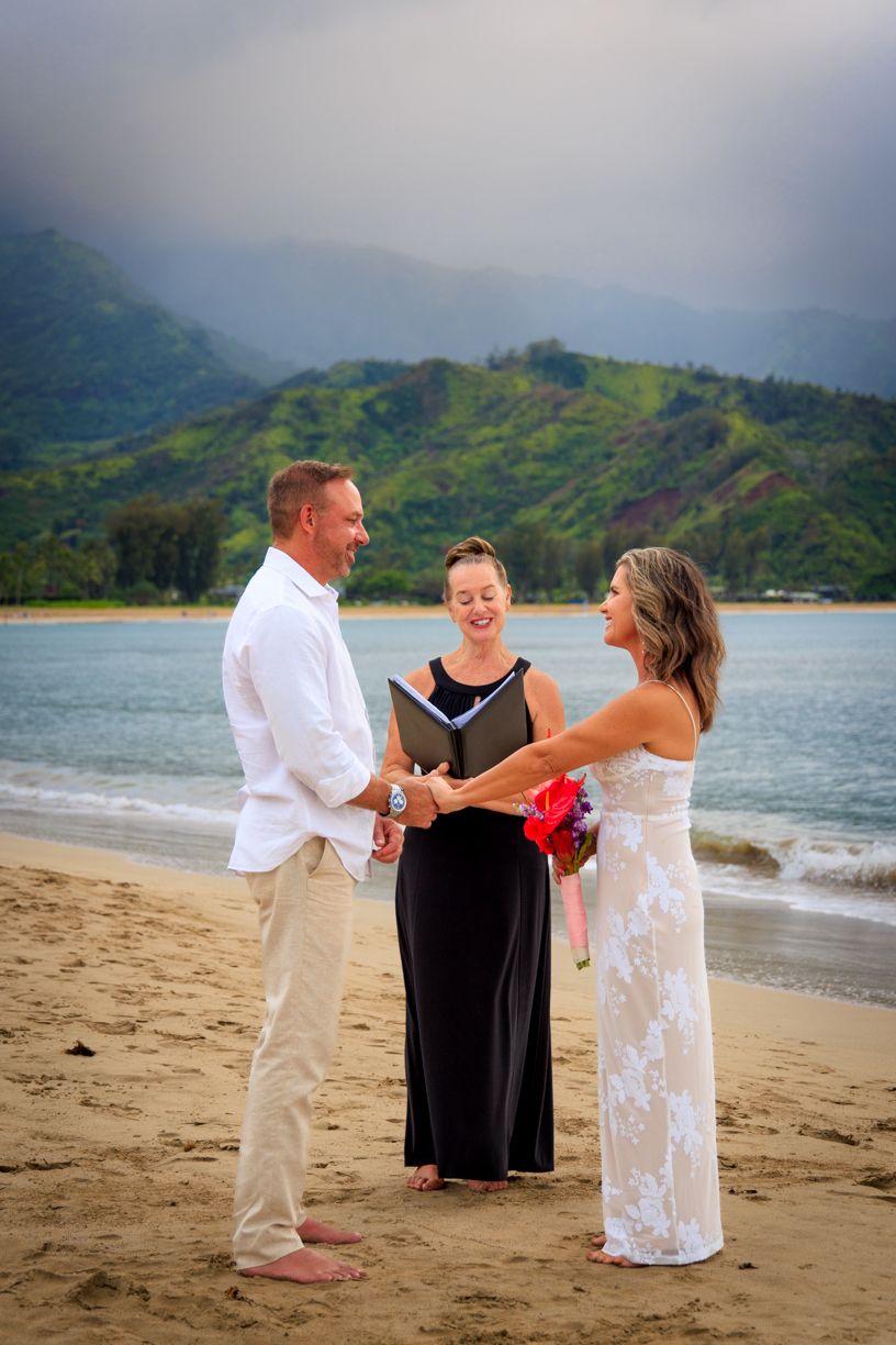 A beach wedding ceremony with mountains in the background.