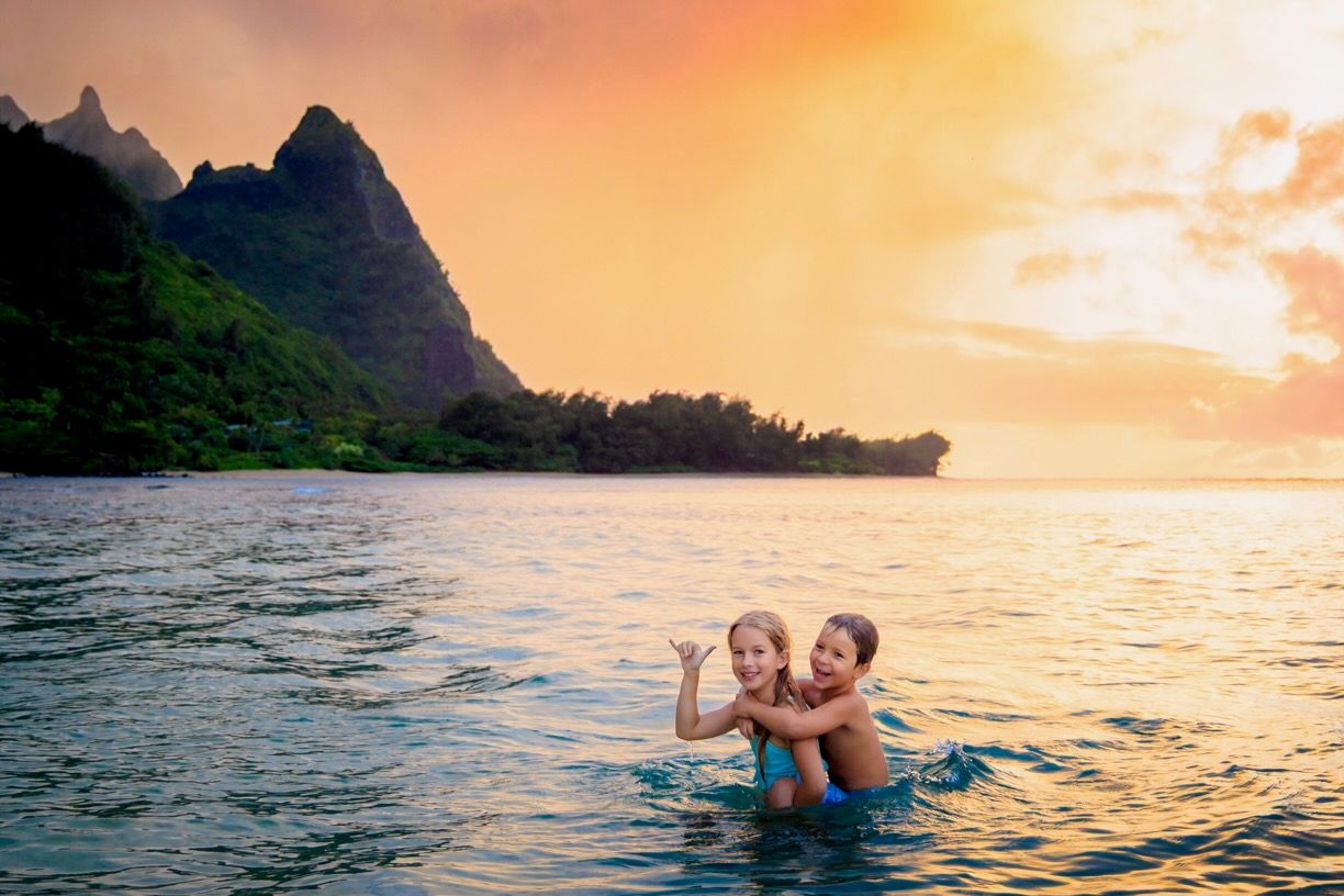 Emotive family portraits at Tunnels Beach with tropical scenery