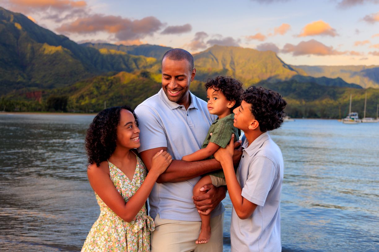 Candid family moments captured against a scenic mountain backdrop during sunset at a tropical beach.