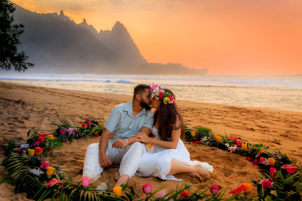 Romantic beach proposal scene with tropical flowers and golden sunset in Hawaii.
