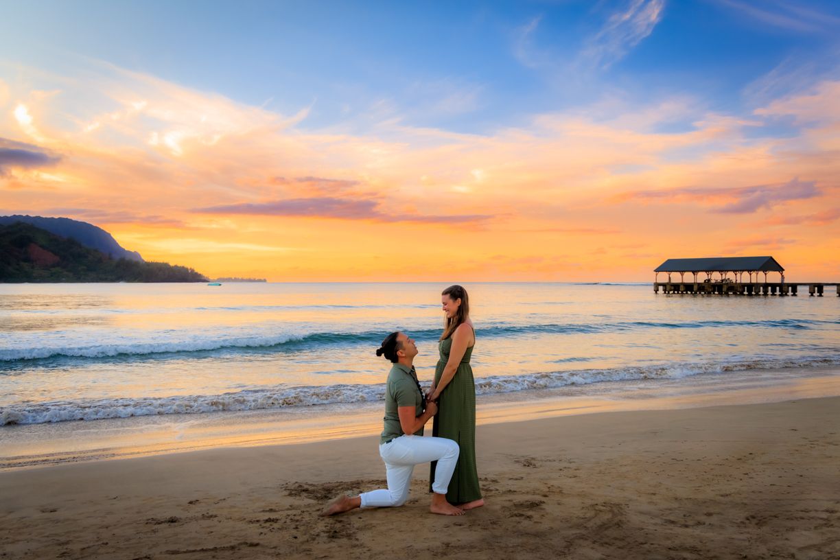 Beachside proposal with pier and vibrant sunset colors.
