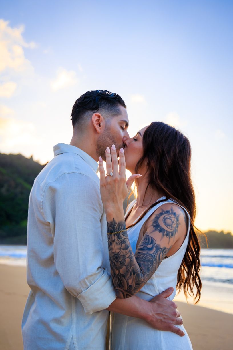 Intimate beach portrait of couple in white clothing during golden hour.