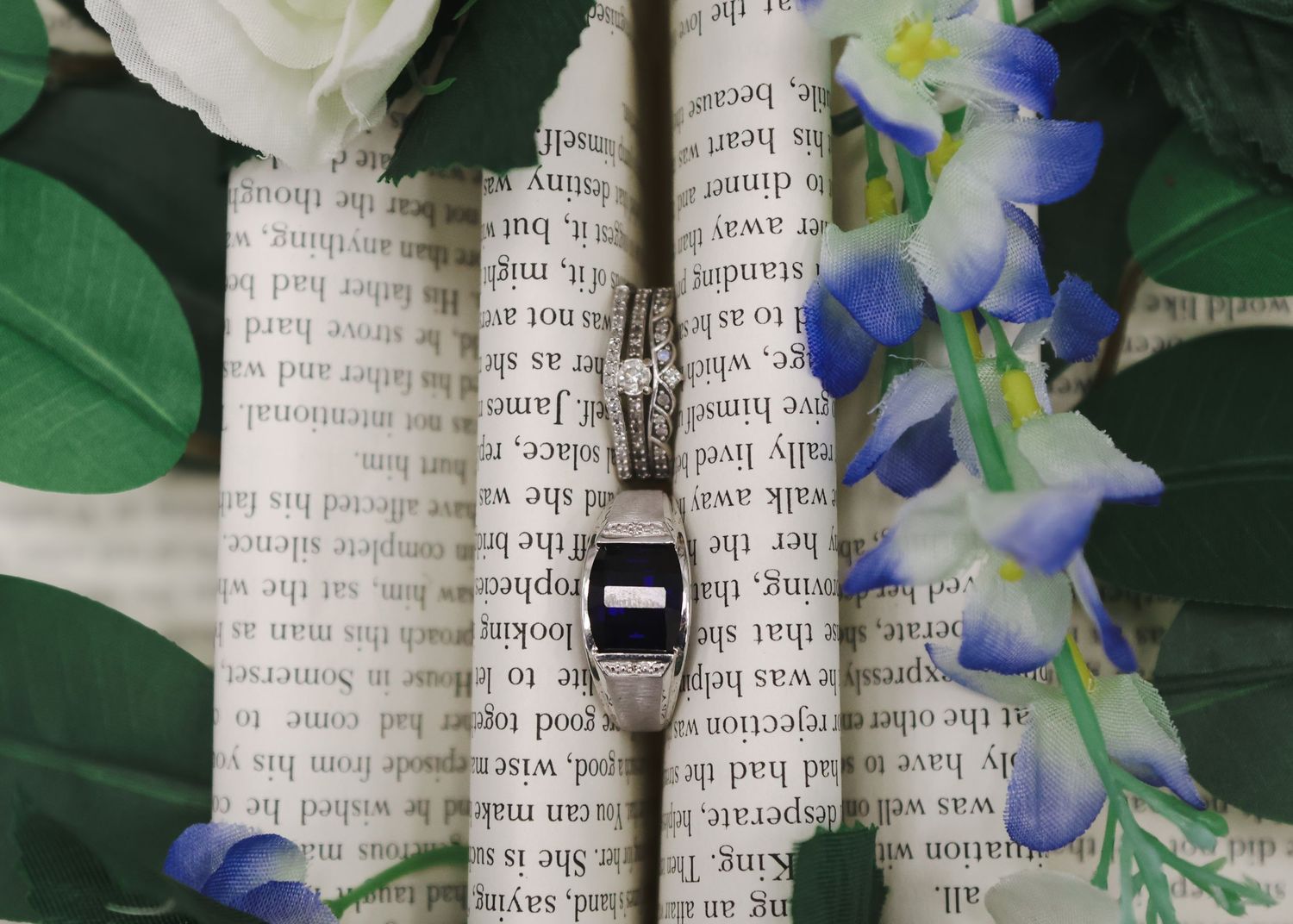 Elegant pendant necklace with dark gemstone displayed on open book with floral background.