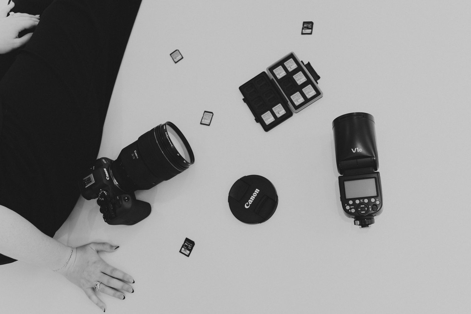 A collection of black and white photographs showing camera lenses and photography equipment arranged on a surface.