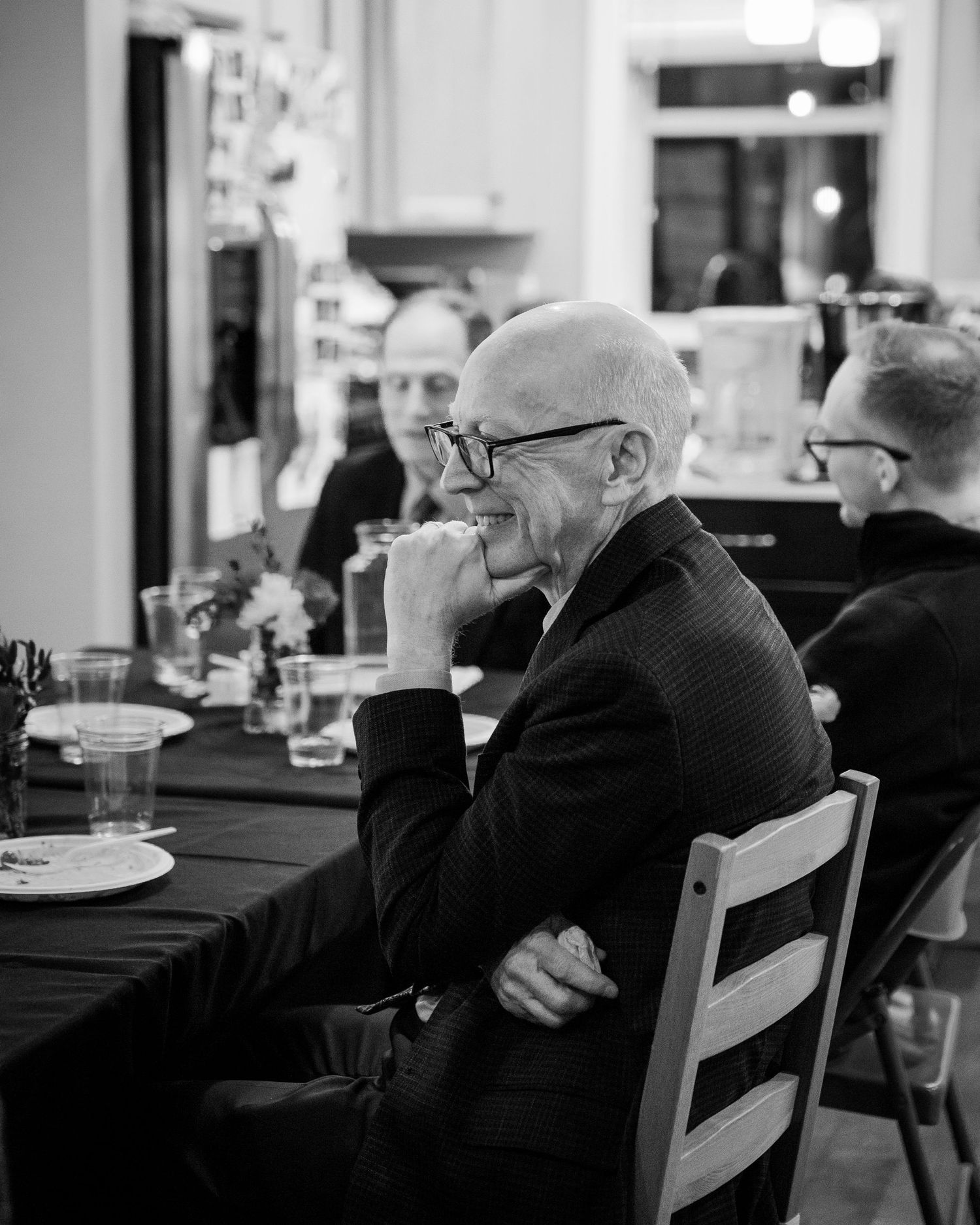 Black and white candid shot of guests seated at a formal dinner event.