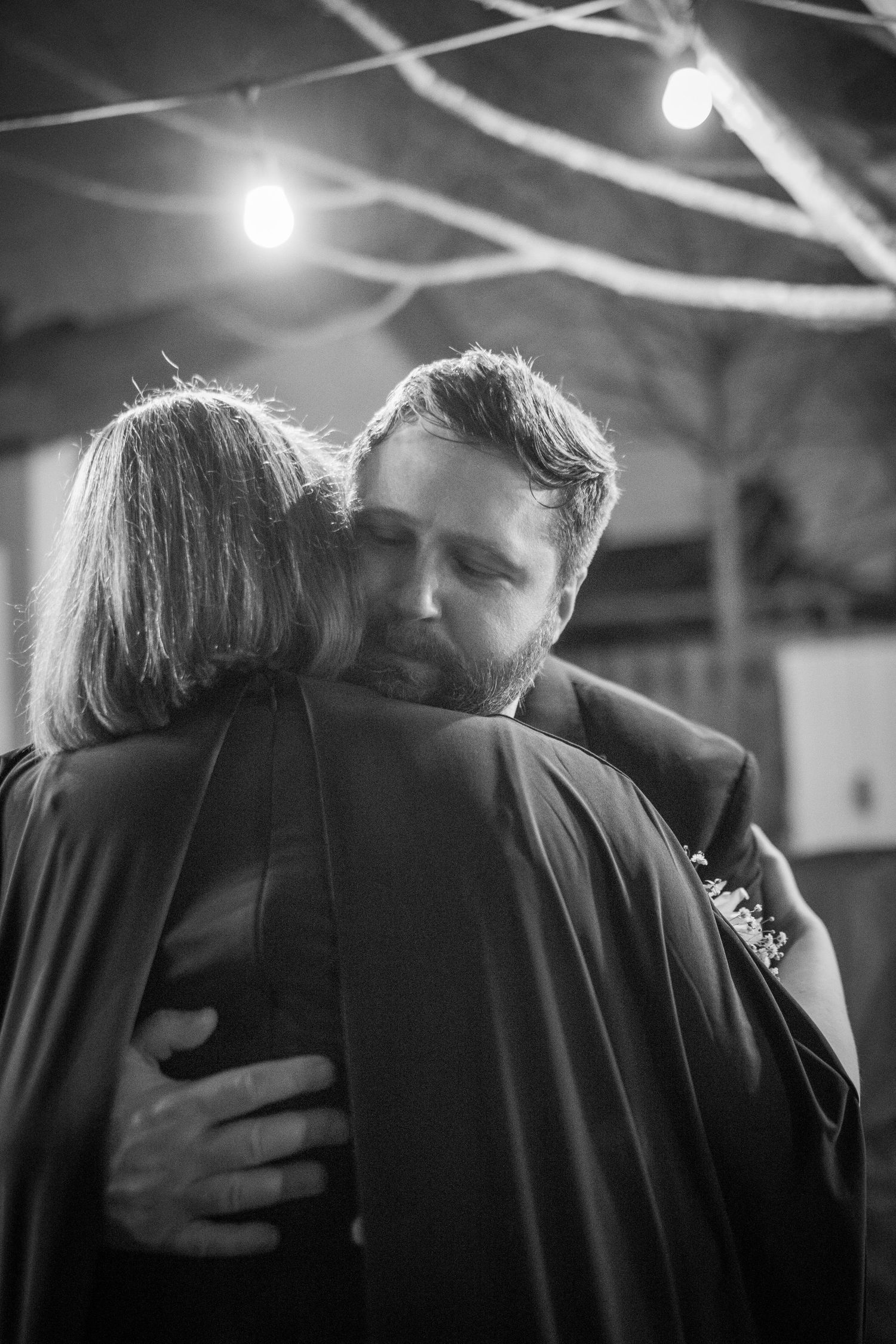 A tender black and white embrace captured under soft lighting.