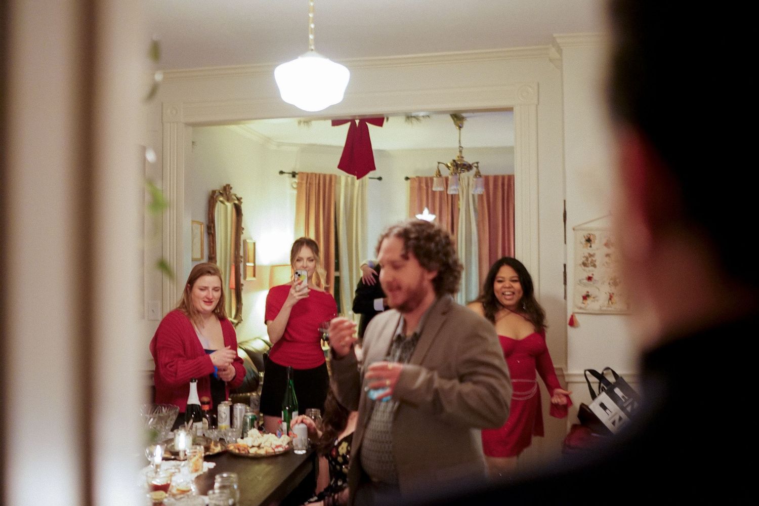 People in red clothing gather in a brightly lit room during a celebration.