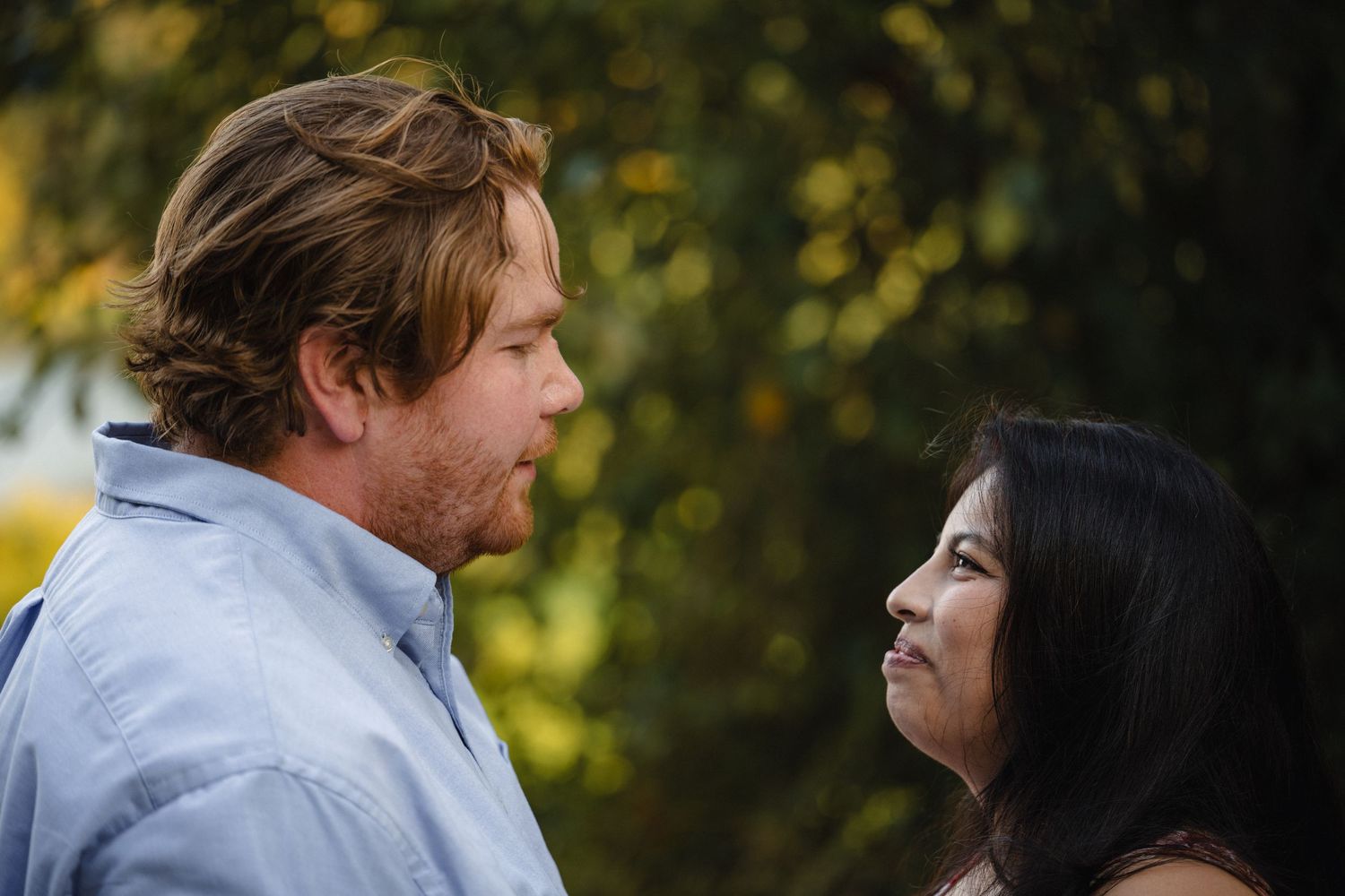 A romantic outdoor photo session showing a couple embracing in warm sunlight.