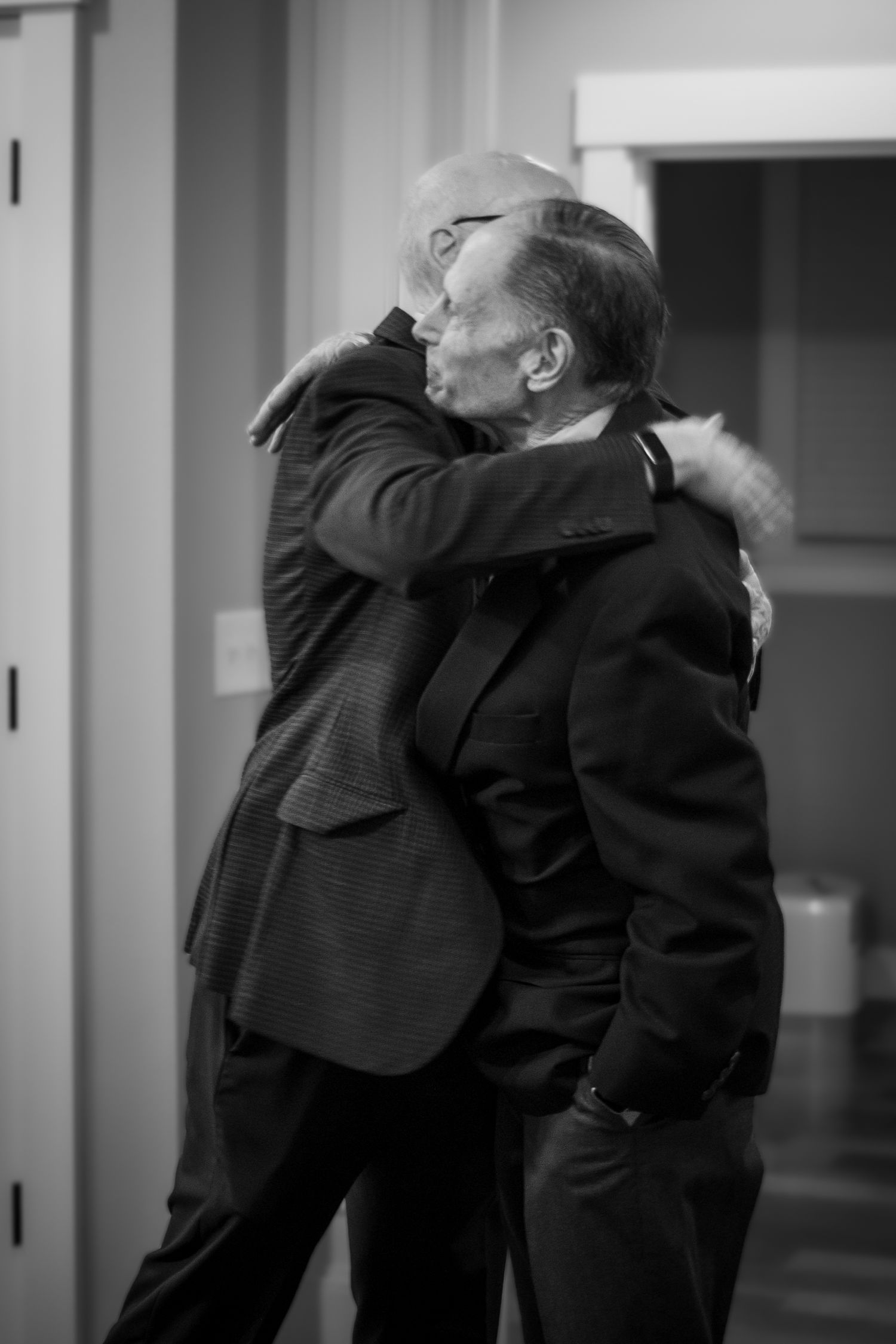 Black and white images of people embracing during an emotional moment.