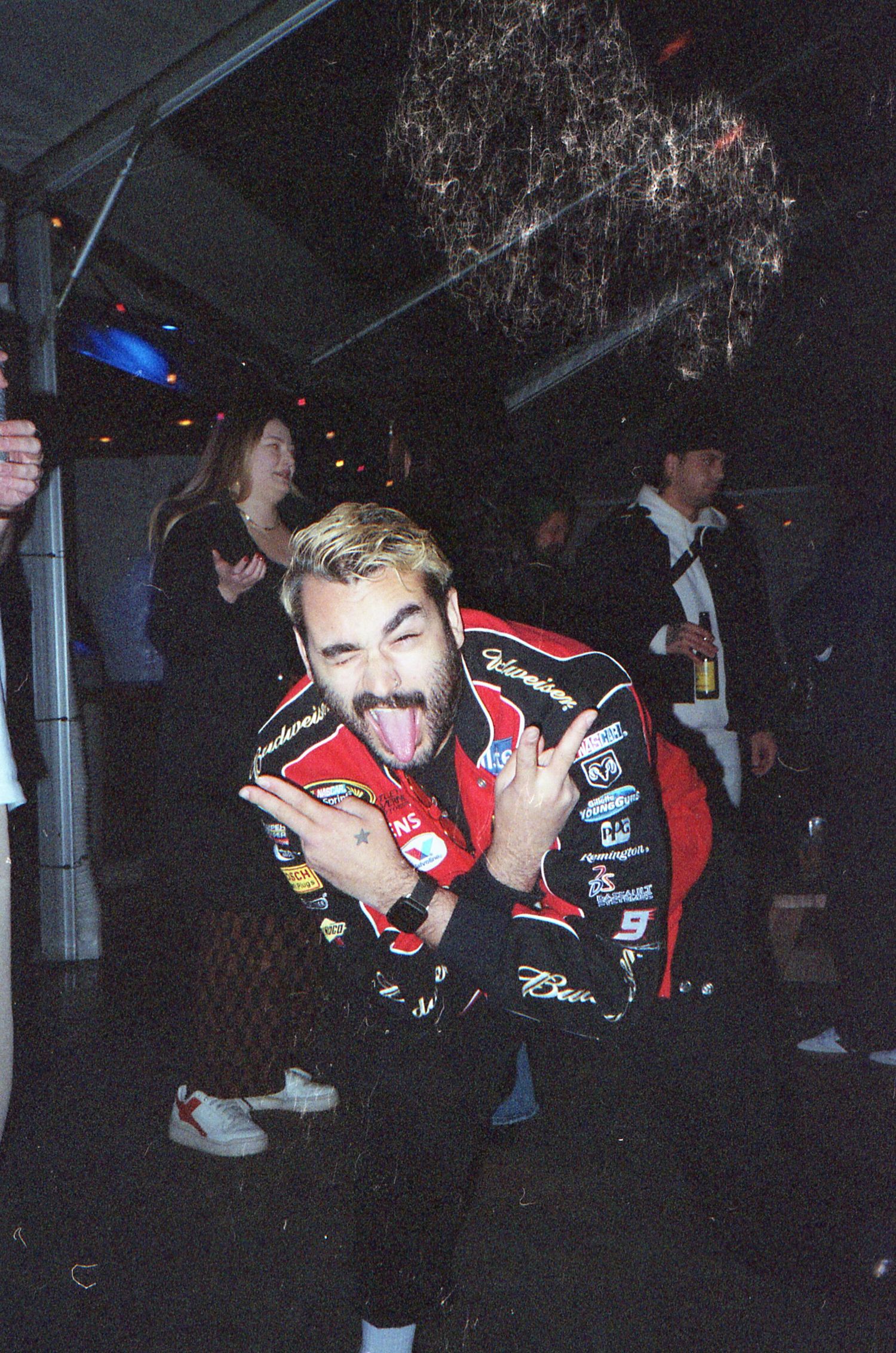 Performers in red jackets dancing and moving energetically during a nighttime outdoor show.