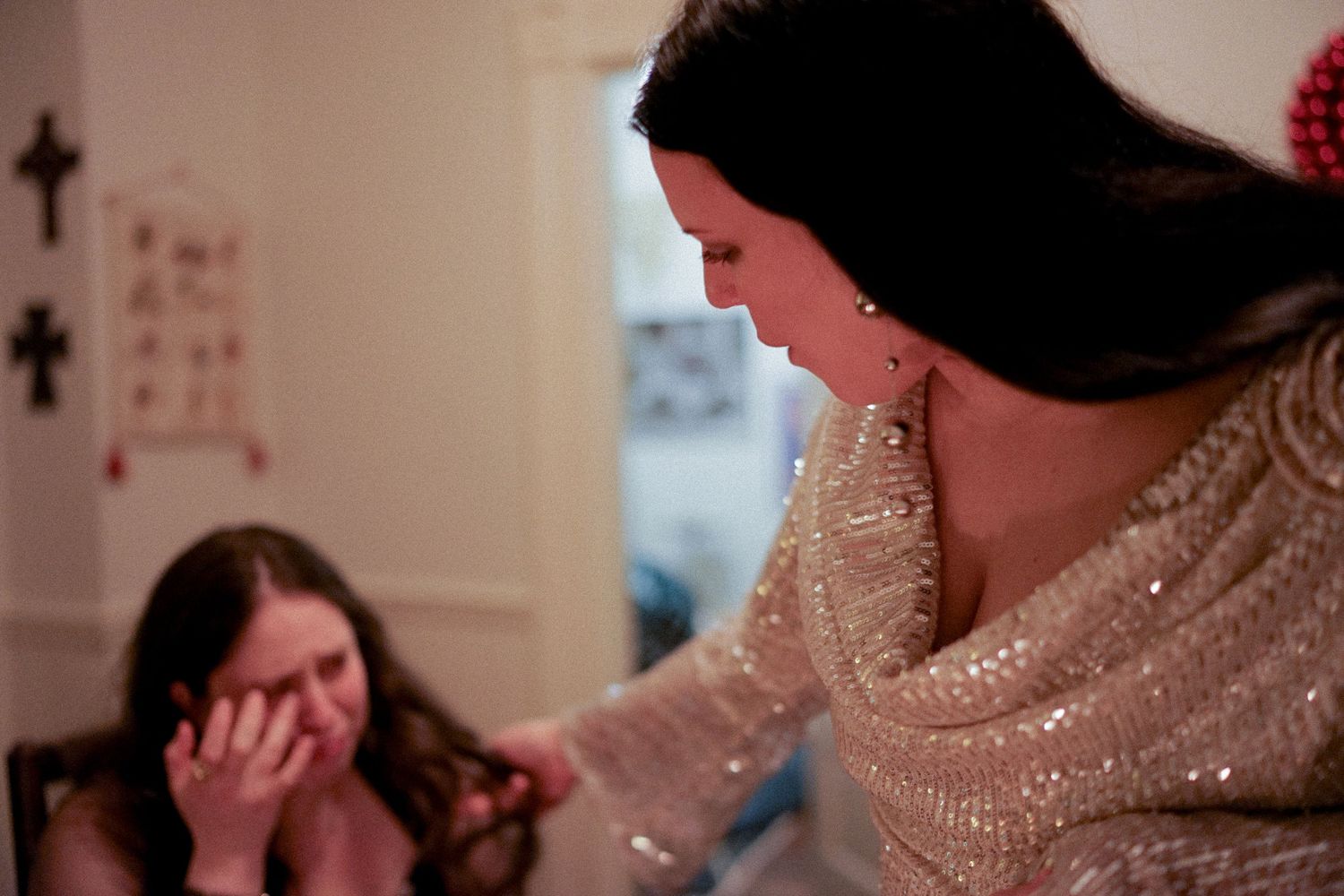 Two people share an emotional moment in a room with holiday decorations.