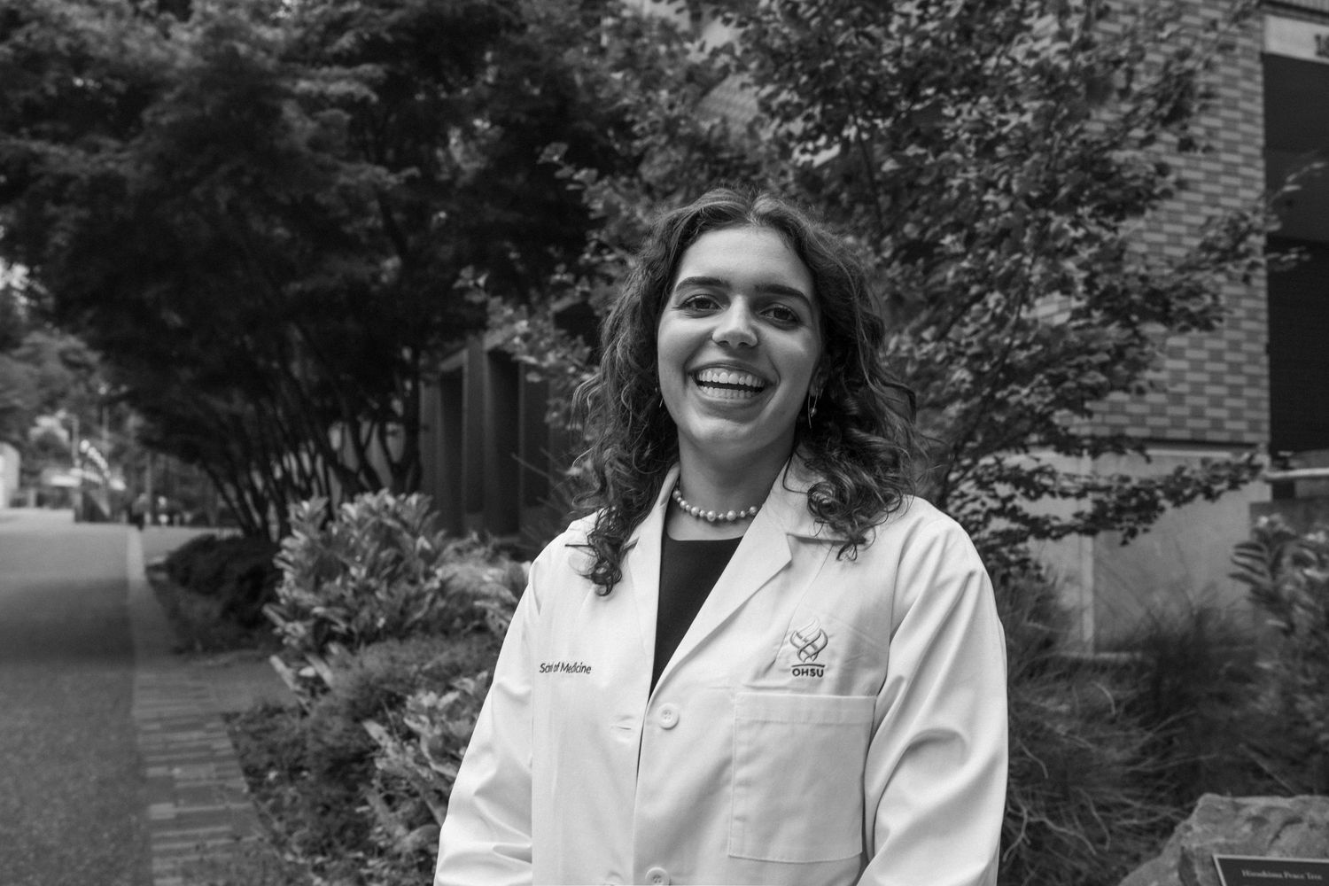 Professional headshots of someone in a white medical coat against a natural outdoor background.