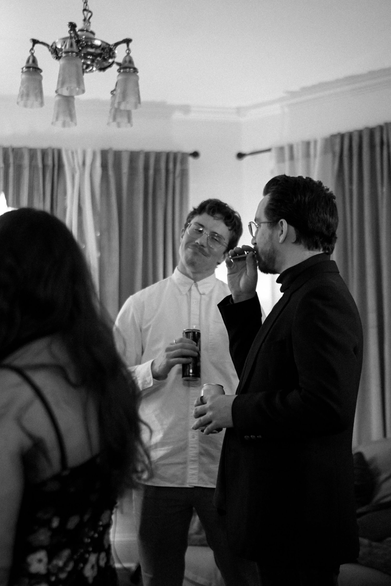 Guests in formal attire chatting during an indoor evening celebration.