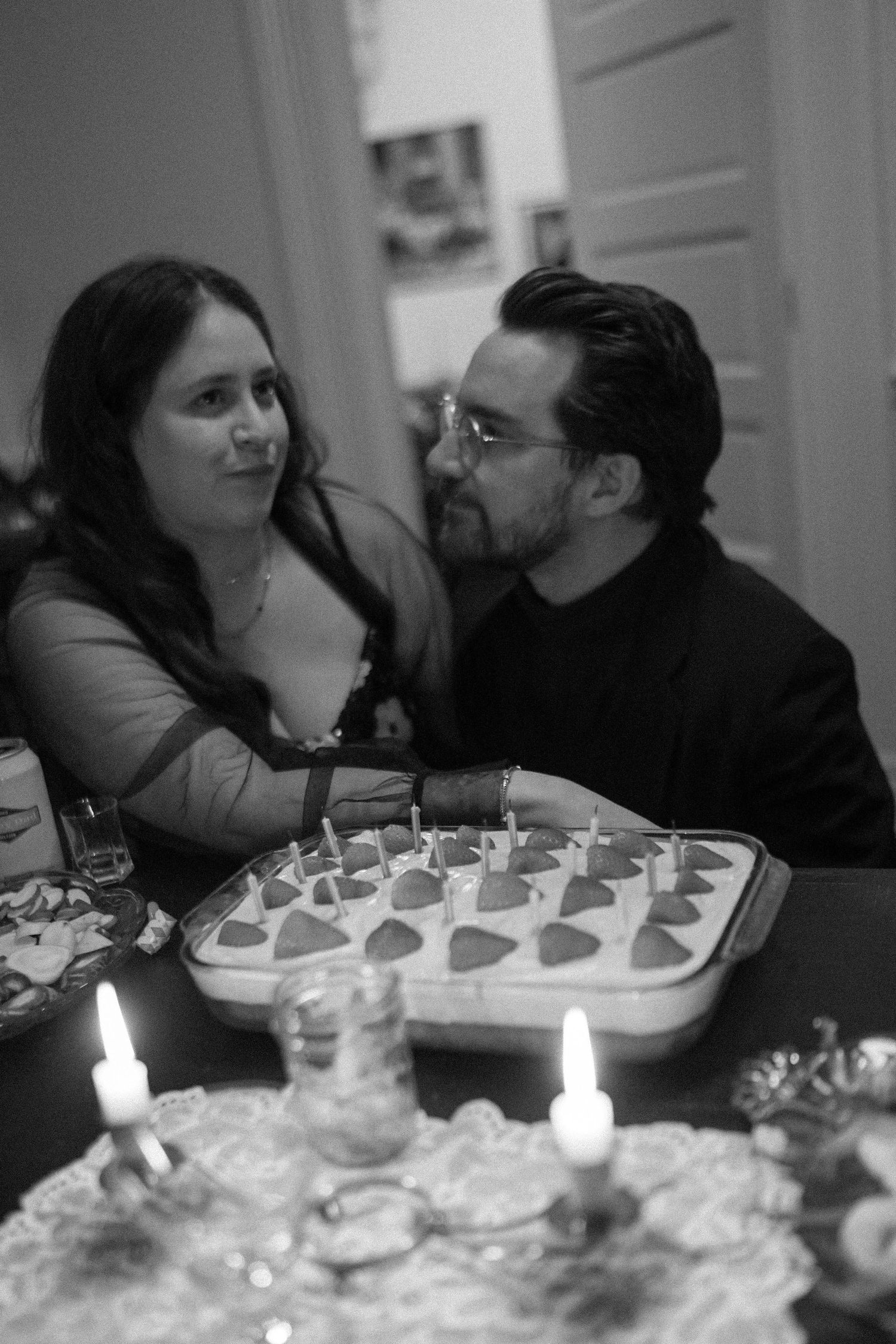 A table set with desserts and candles during an intimate gathering.