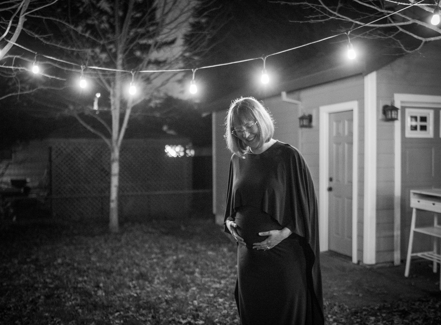 String lights illuminate a nighttime outdoor scene with silhouetted figures.