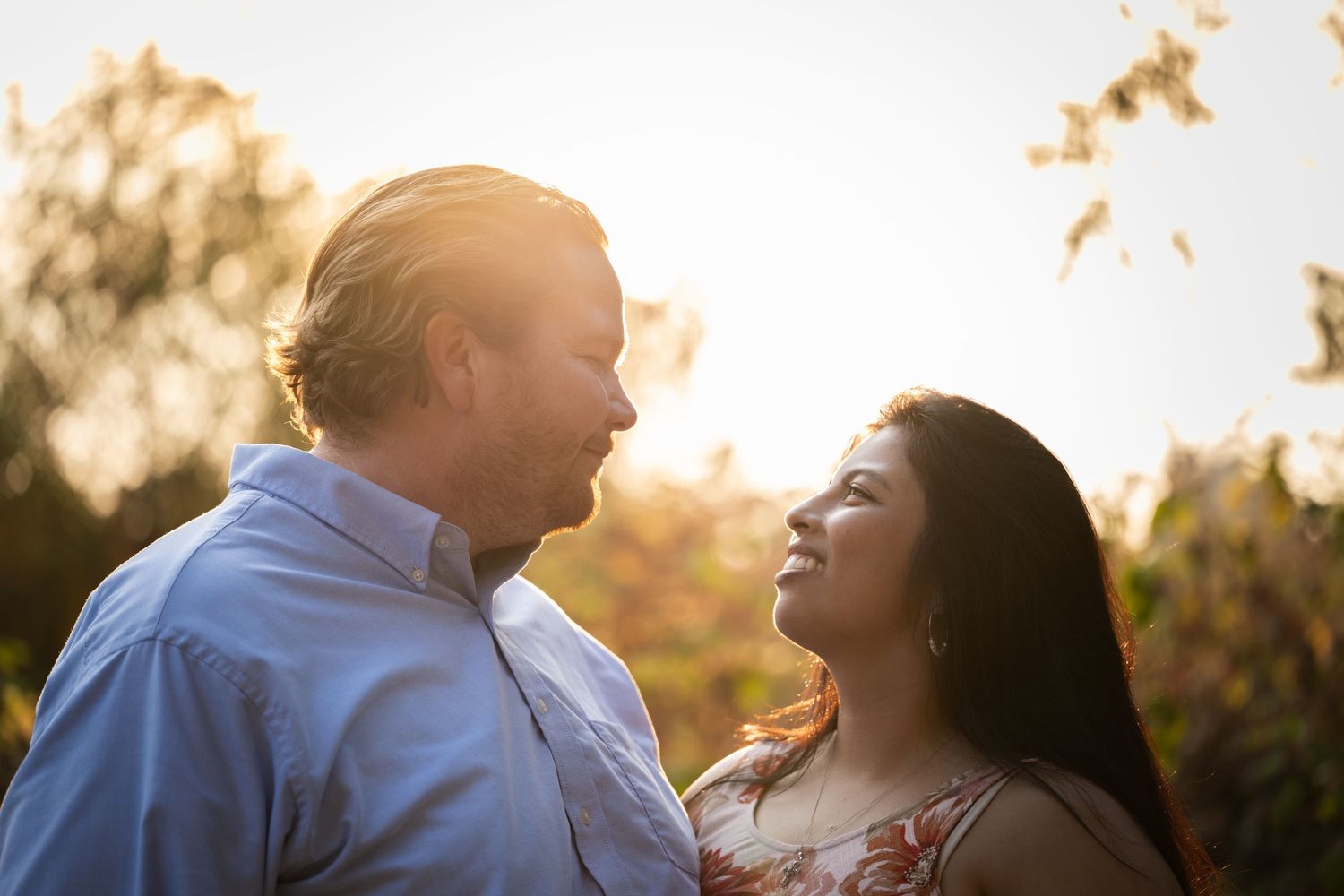 Romantic couple silhouetted against golden sunset light.