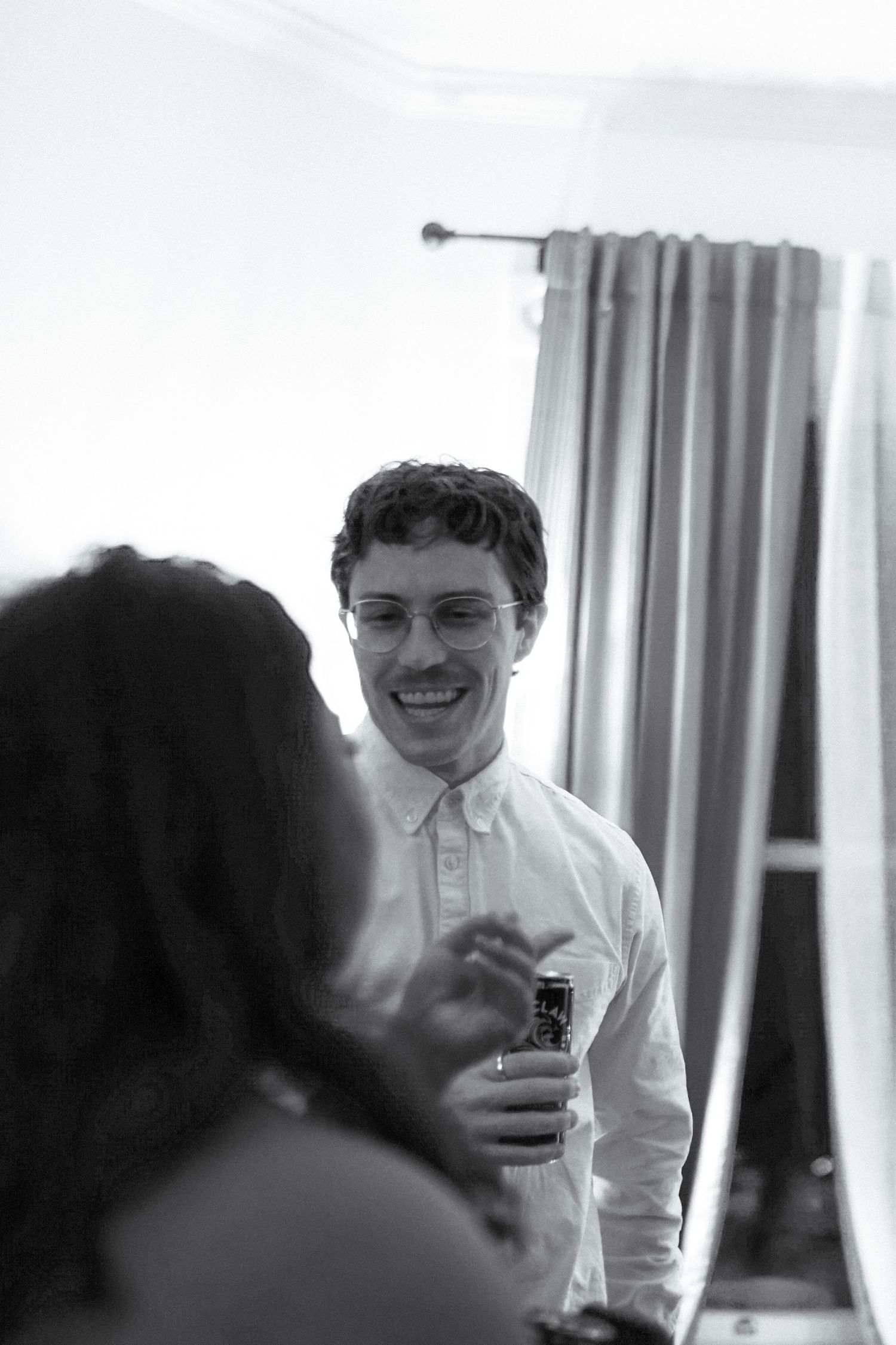 A candid black and white party photo showing guests enjoying conversation indoors.