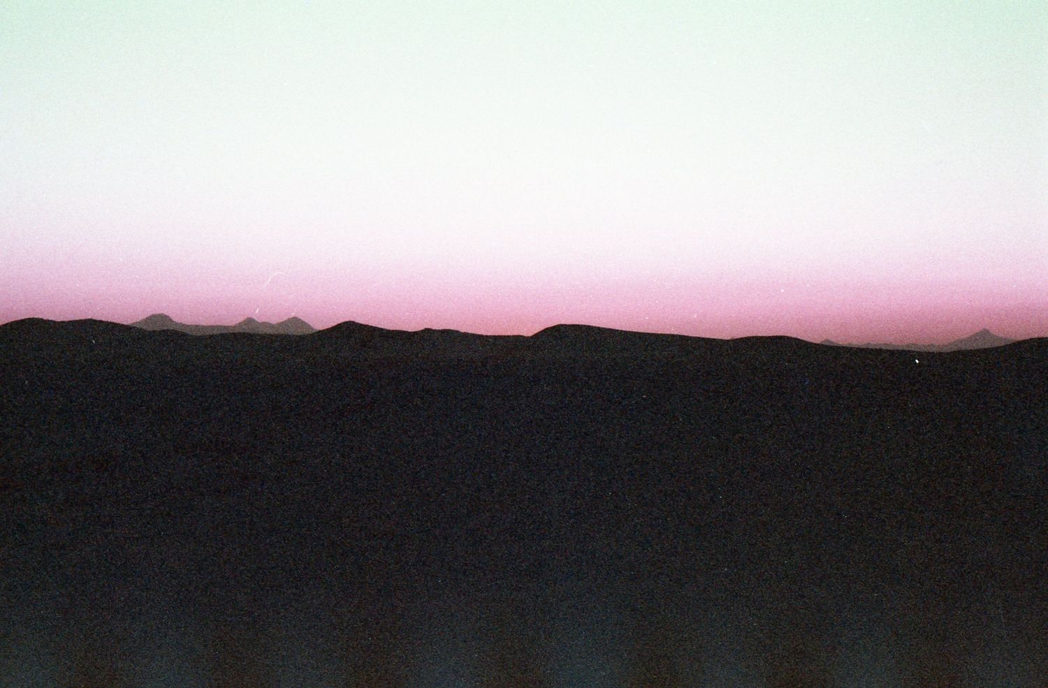 A panoramic sequence showing the progression of a sunset over mountains with changing colors in the sky.