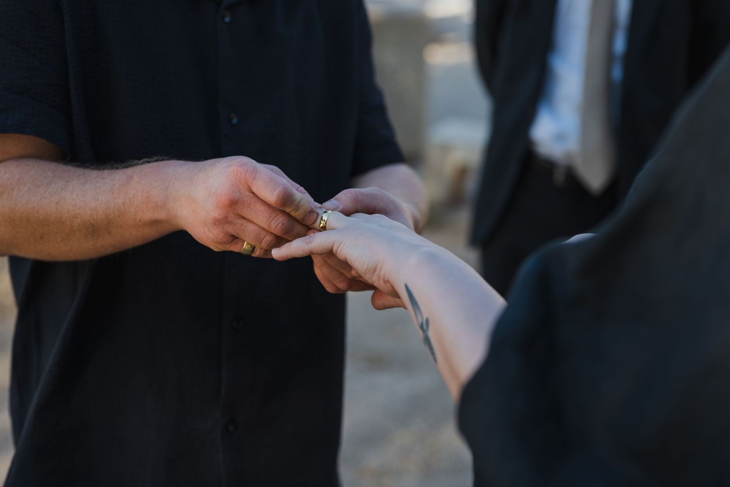 Close-up sequence of hands exchanging rings during a ceremony.