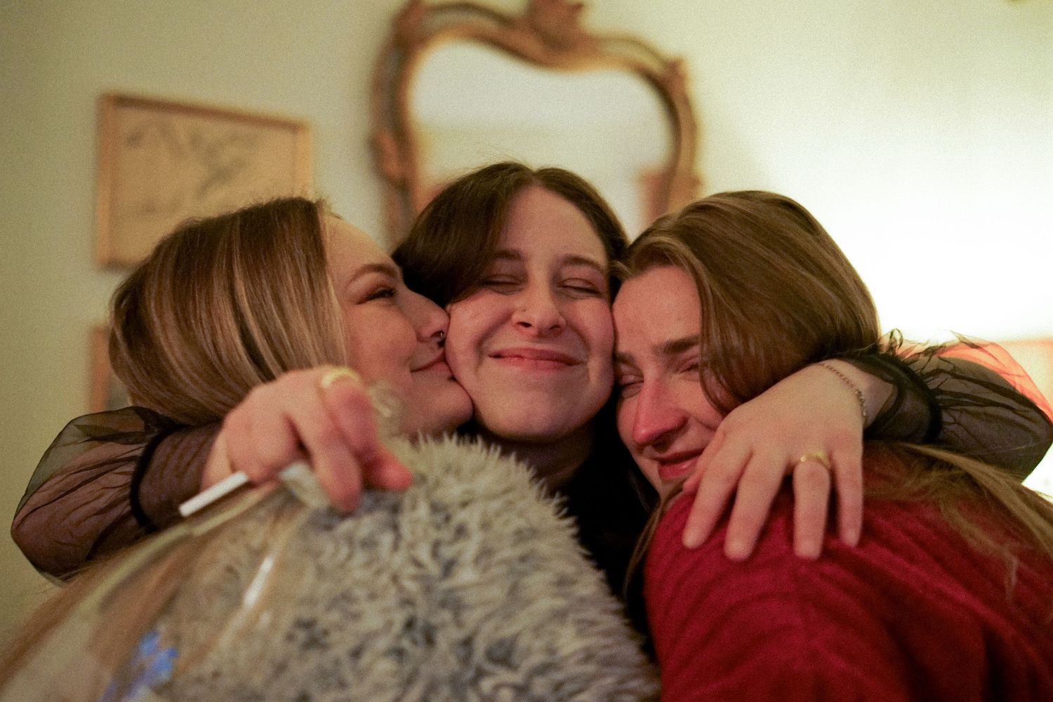 Three friends share a warm embrace during a heartfelt moment.