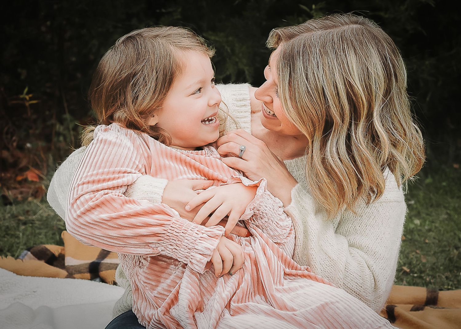 A heartwarming outdoor photo series showing tender moments between mother and child in casual striped clothing.
