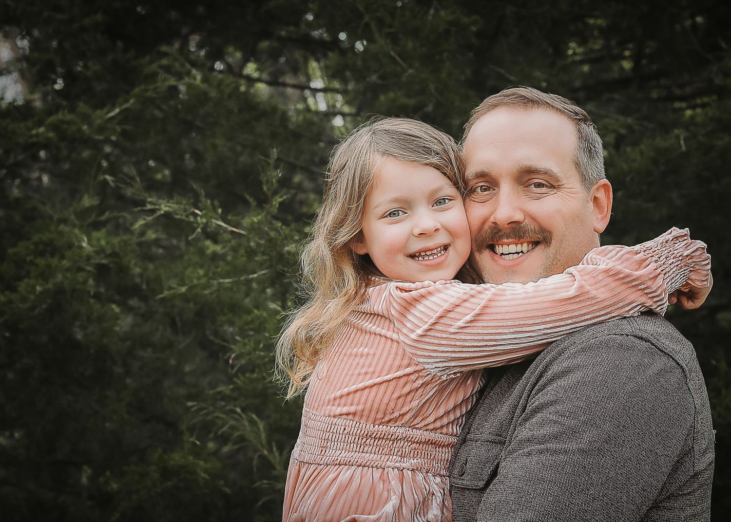 A parent and child in matching outfits share warm embraces while laughing outdoors in multiple candid photos.