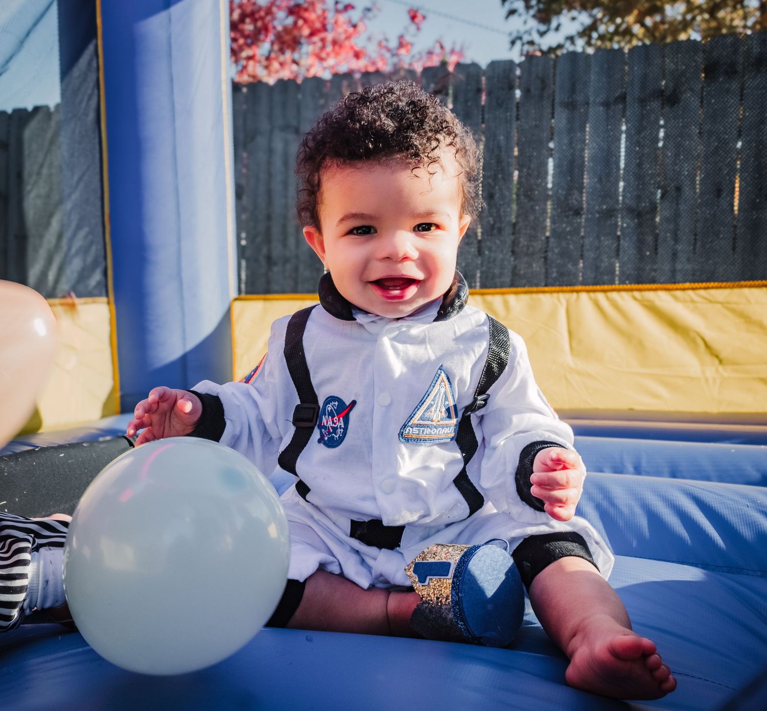 A sequence of playful moments in a white bounce house showing joyful expressions and interactions with white balloons.
