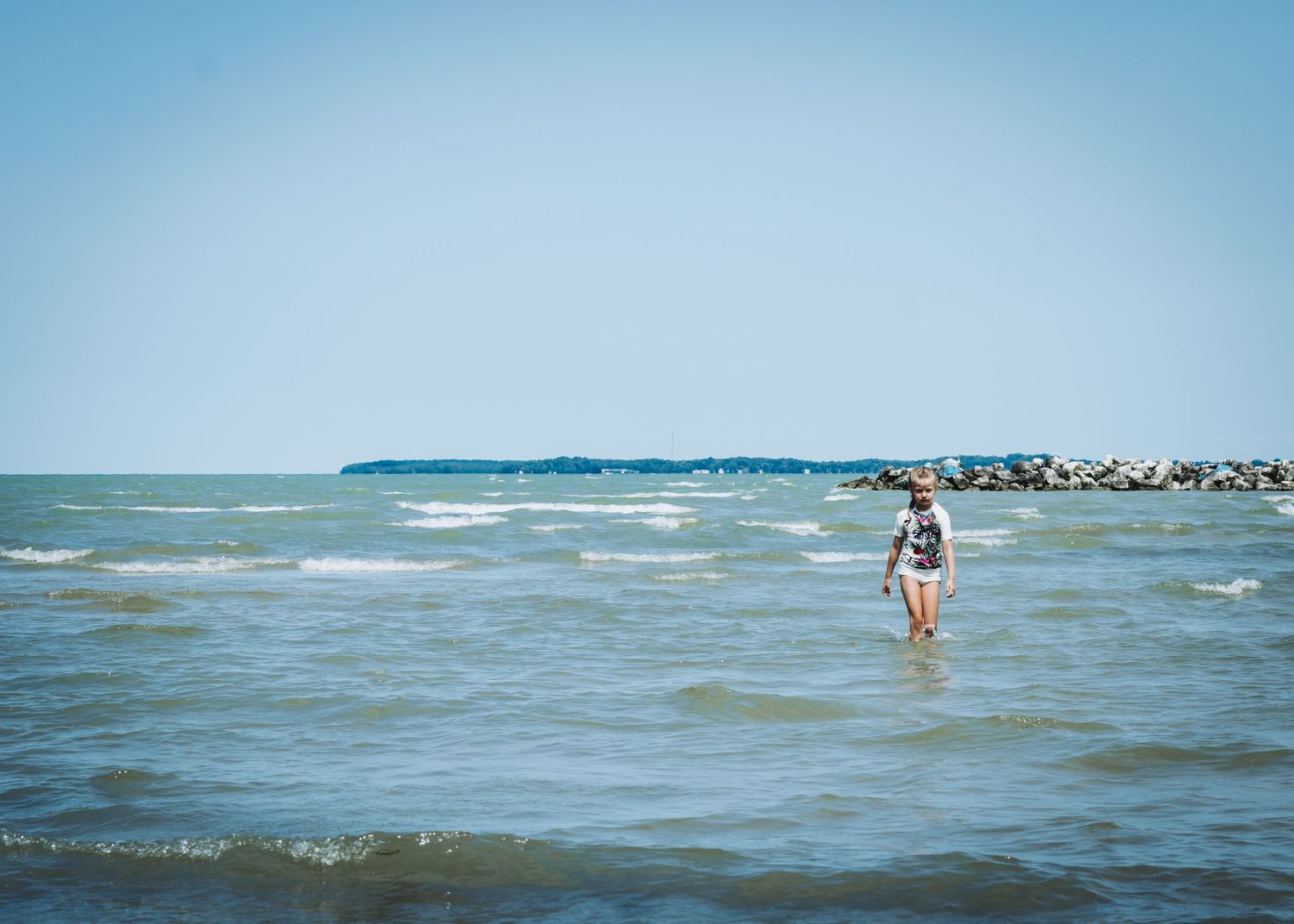 A sequence of ocean beach photos showing people enjoying the waves and water along a sunny coastline.