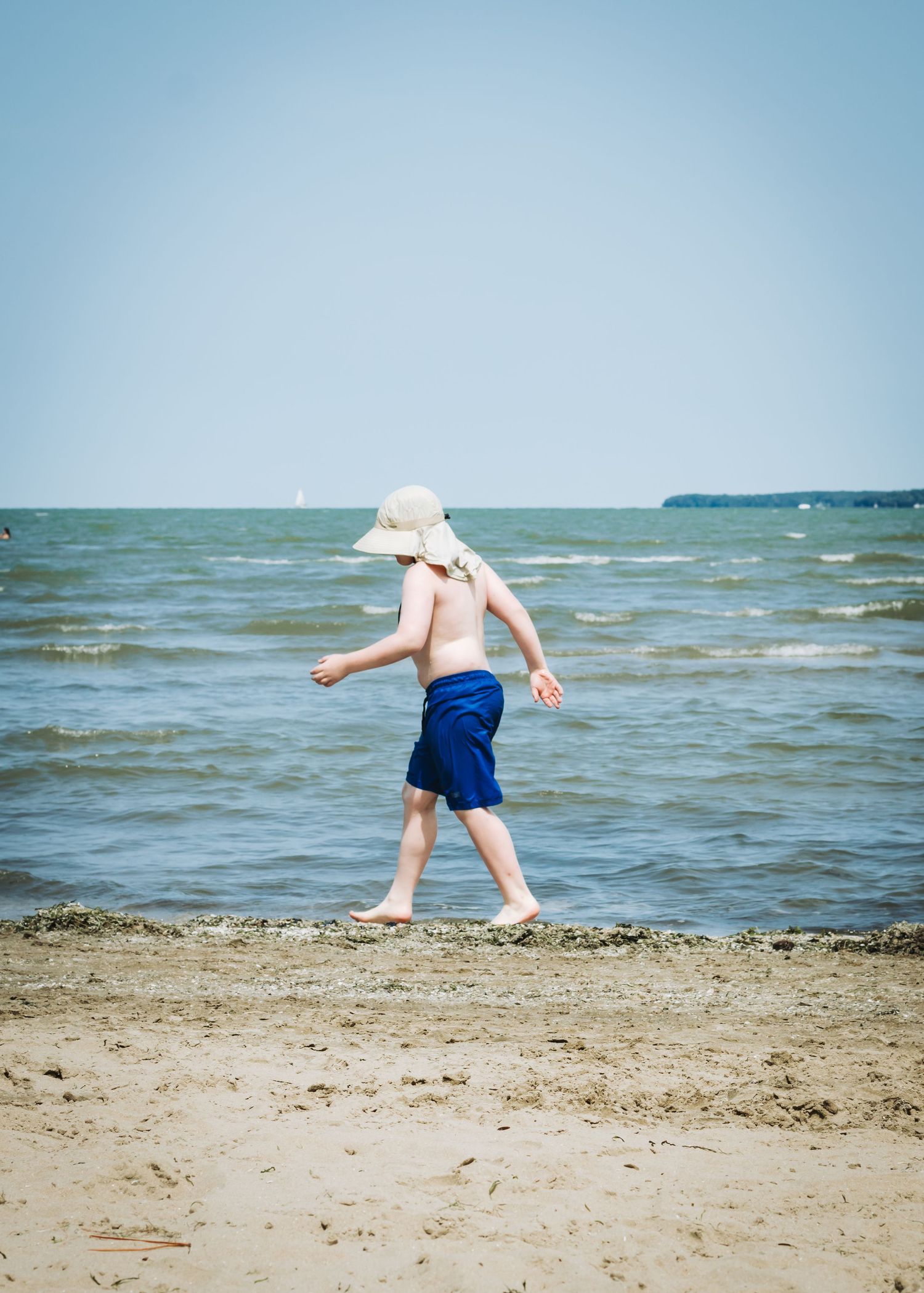 A sequence of photos showing someone exploring the shallow waves at the beach on a sunny summer day.