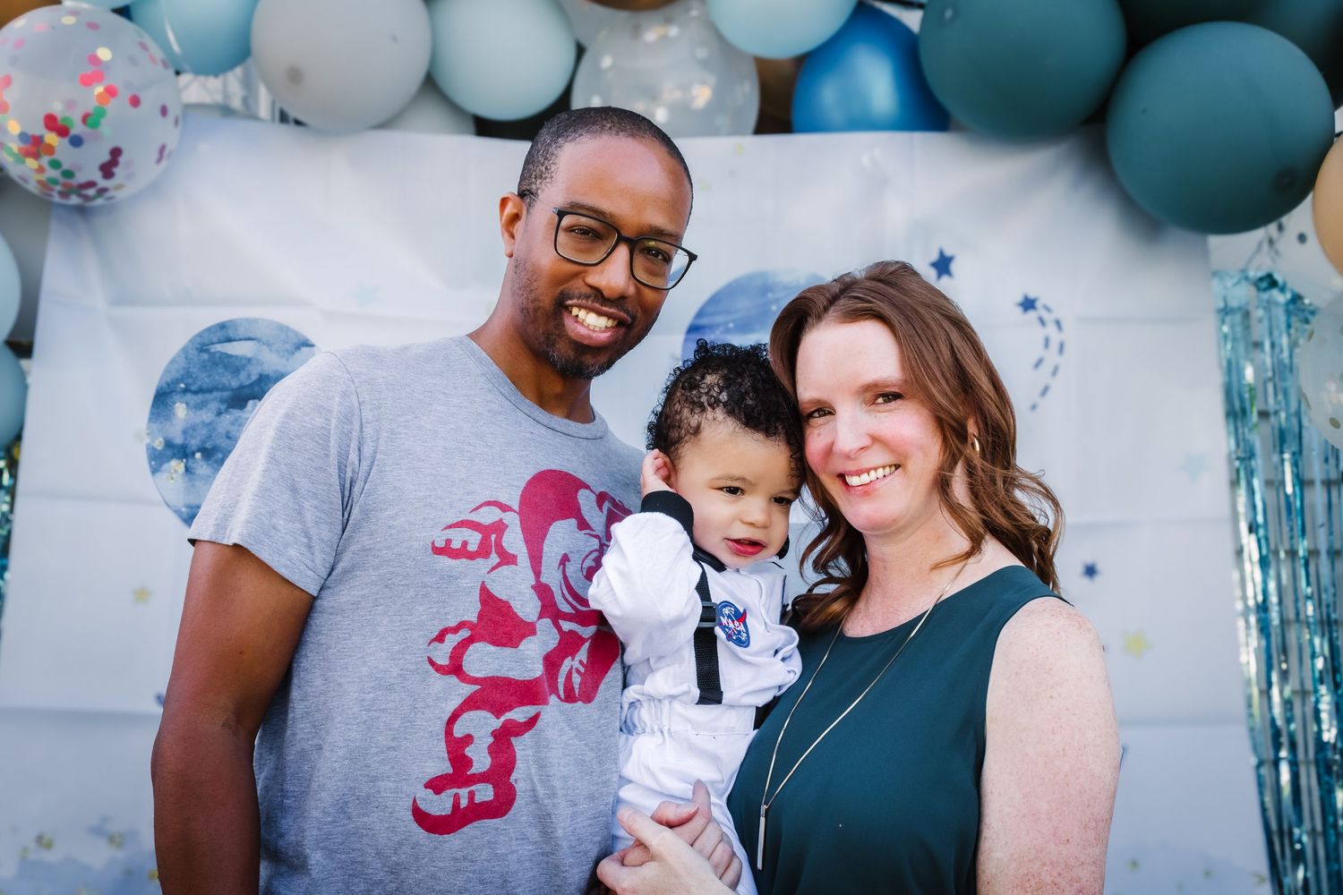 A party celebration with blue and white balloons features a lively gathering of people enjoying festivities together.