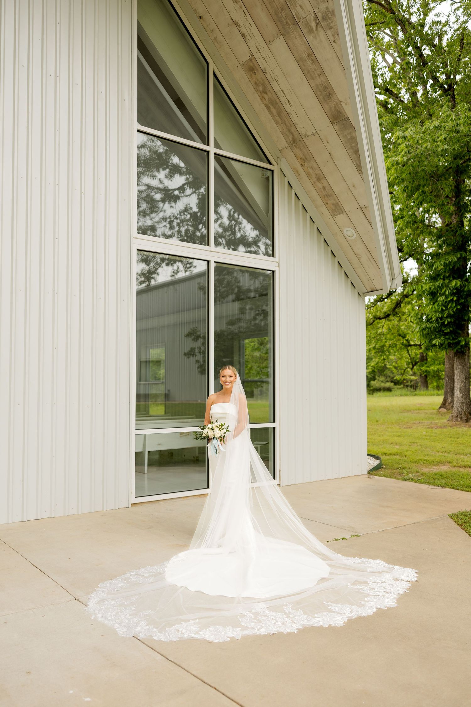 Stunning bridal portrait outside modern white church building with flowing veil.Cold Springs Events