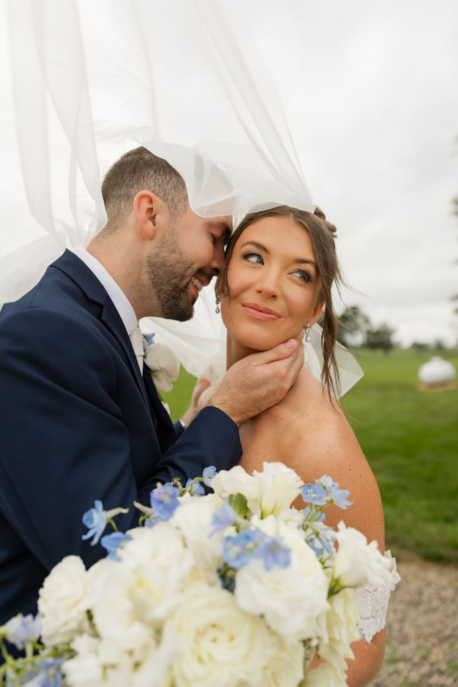 A romantic wedding photo series showing tender moments between newlyweds with a white and blue floral bouquet.