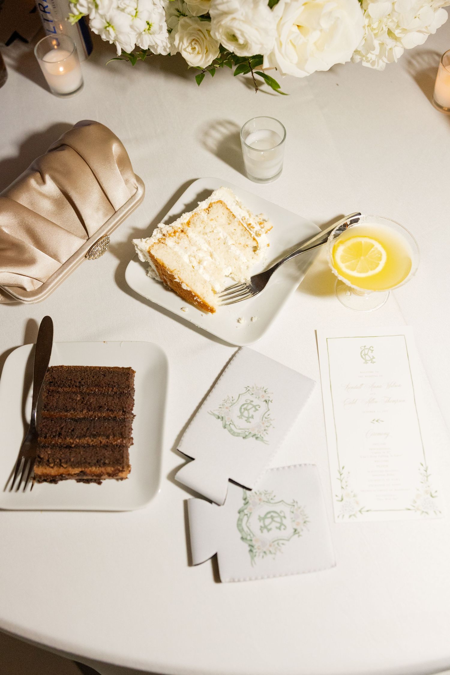 Elegant table setting with chocolate cake slices, white flowers, and place cards on a bright white surface.Cold Springs Events.