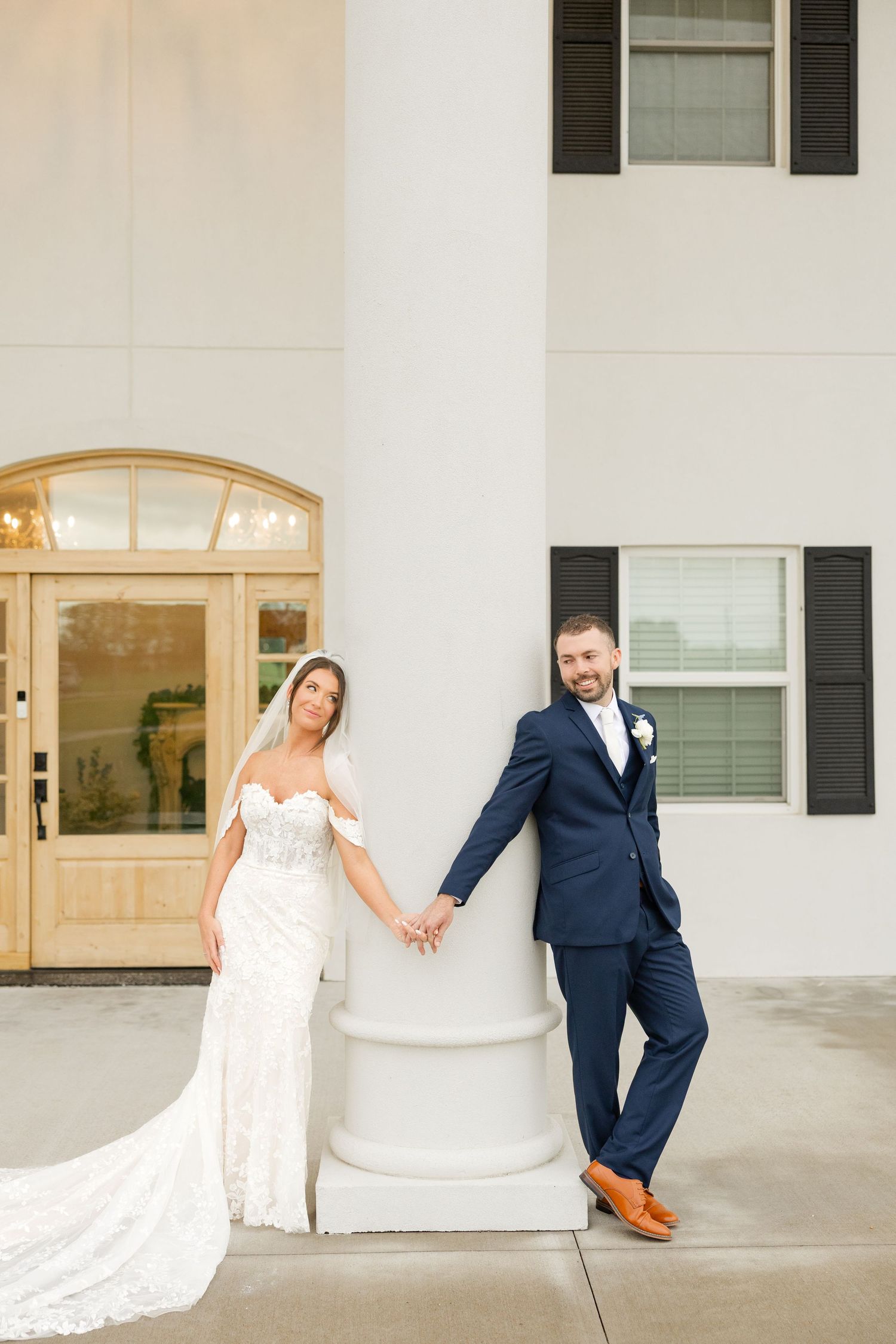 Wedding venue exterior featuring classic white columns and black shutters with elegant architecture.