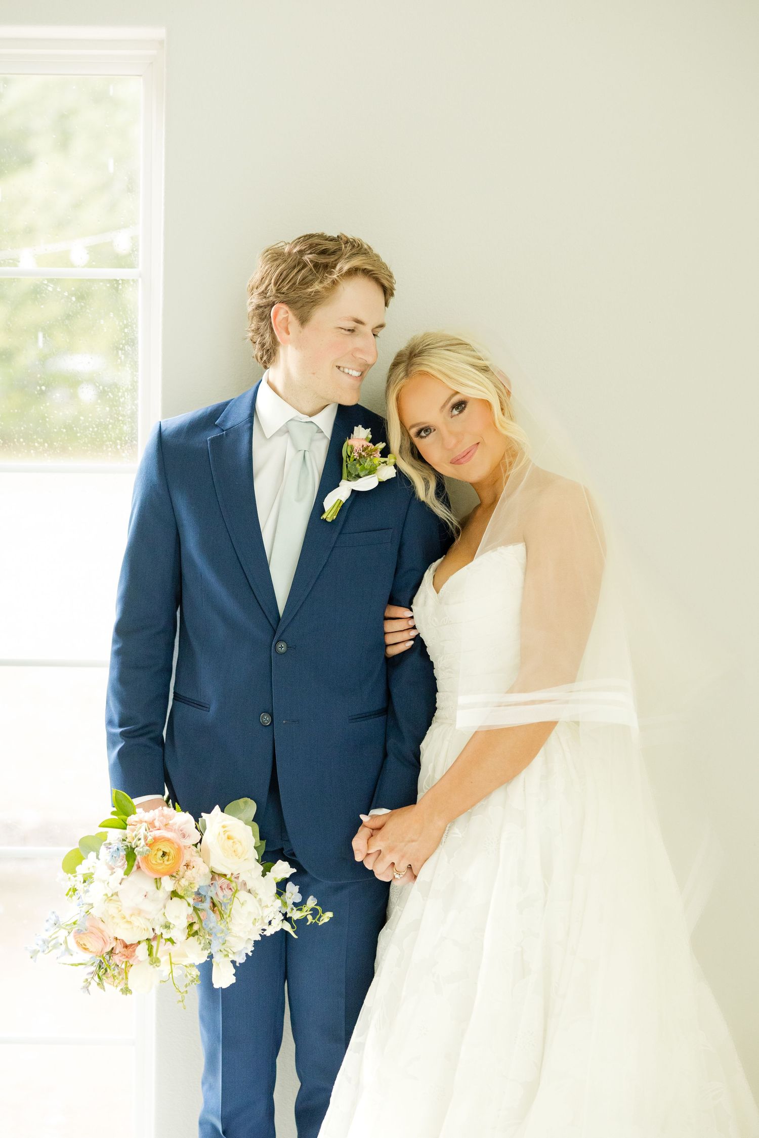 Light and airy wedding portraits against a white wall with soft natural lighting. Grandeur House