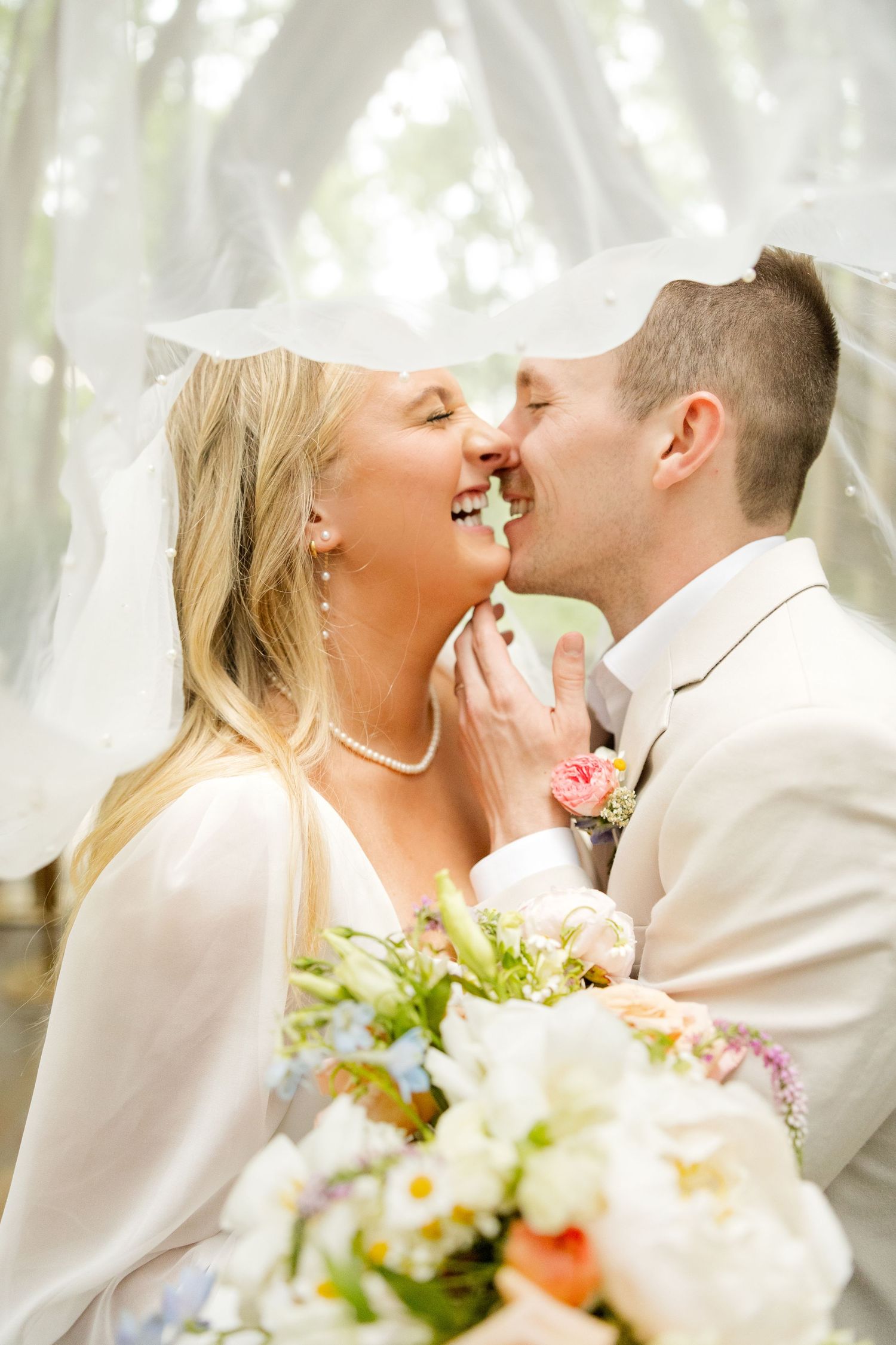 A joyful wedding moment captured with white flowers and soft natural lighting. Mildred B. Cooper Chapel