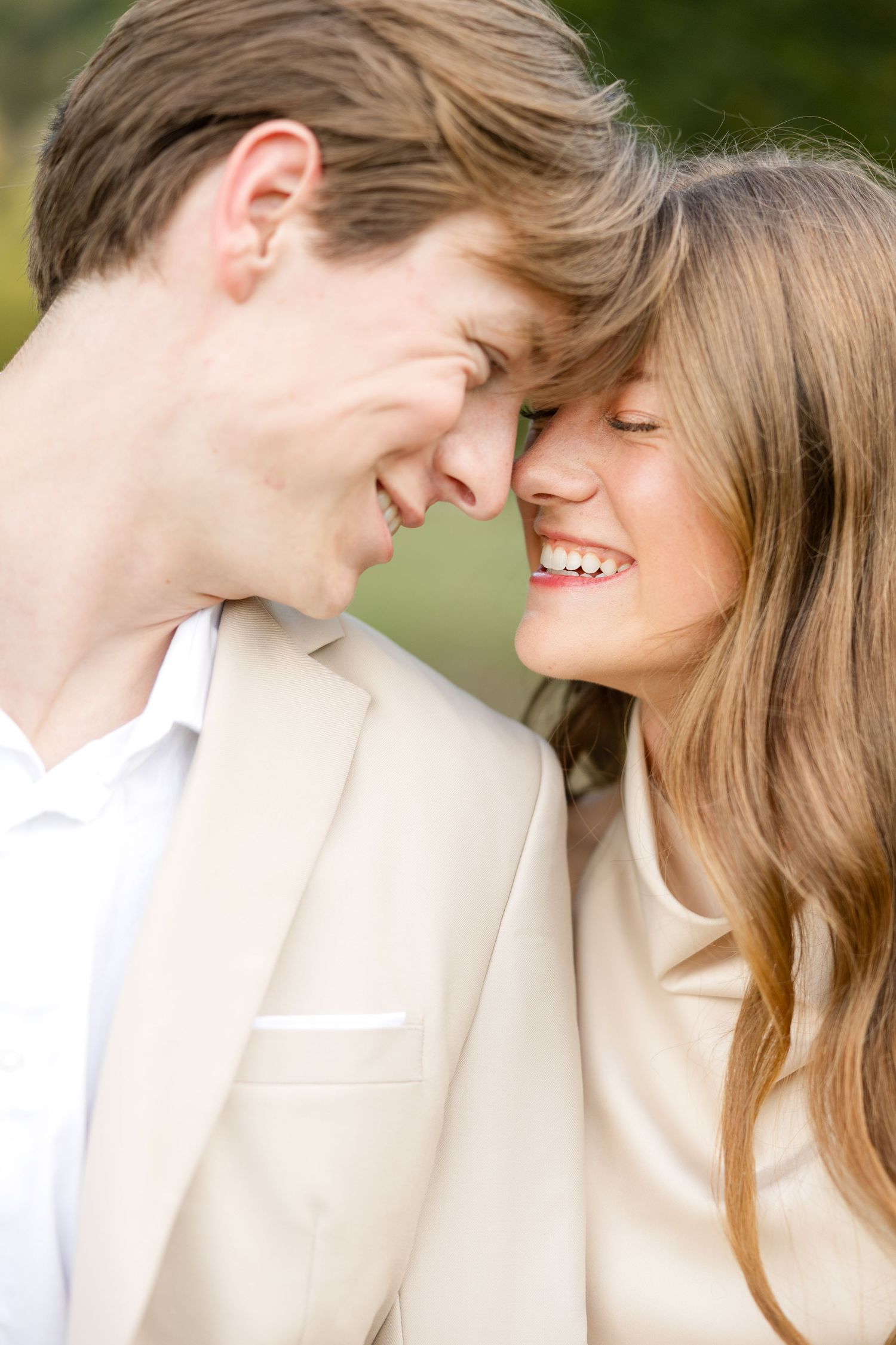 Close up of a couple sharing an intimate moment against a soft neutral background.