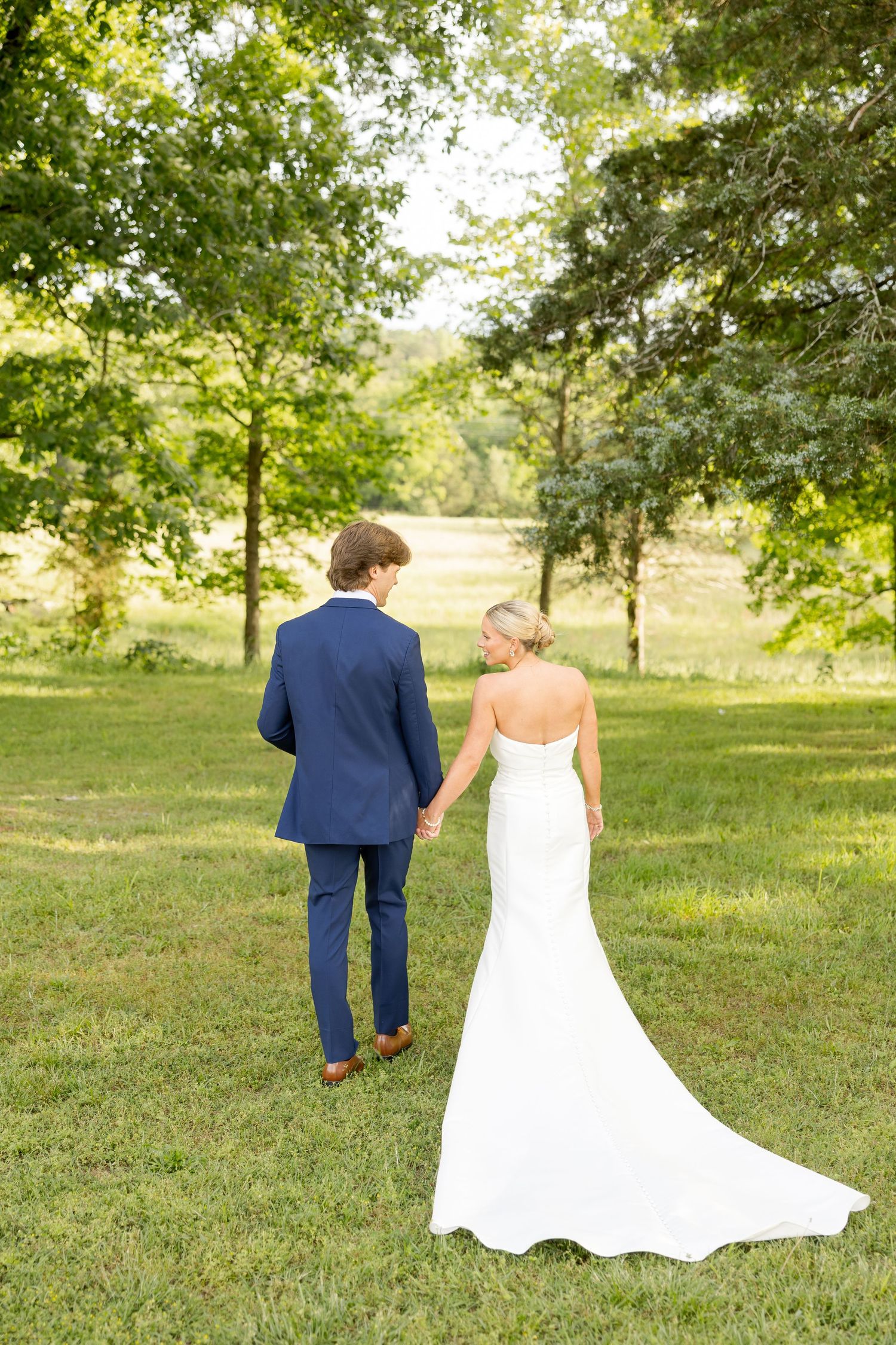 Wedding couple walking through a scenic garden setting.Cold Springs Events