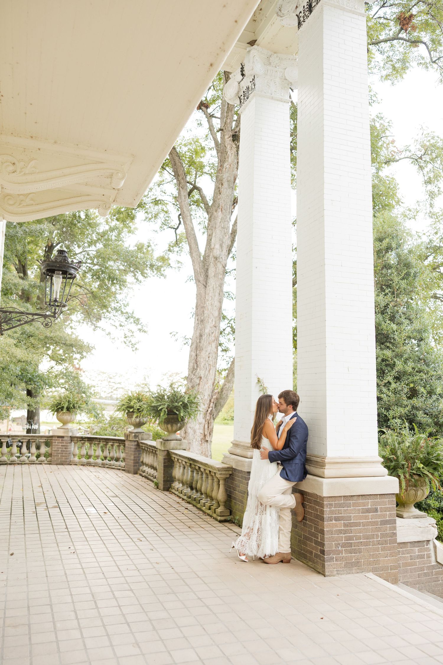 A series of romantic moments captured on a bright white columned porch with brick details.