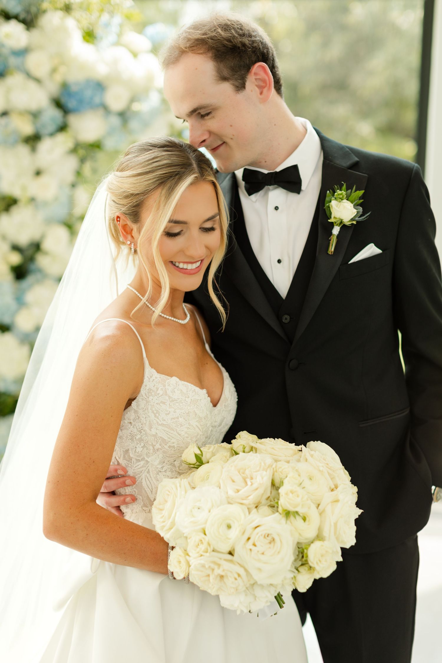 An elegant wedding portrait with a classic white rose bouquet. Osage House