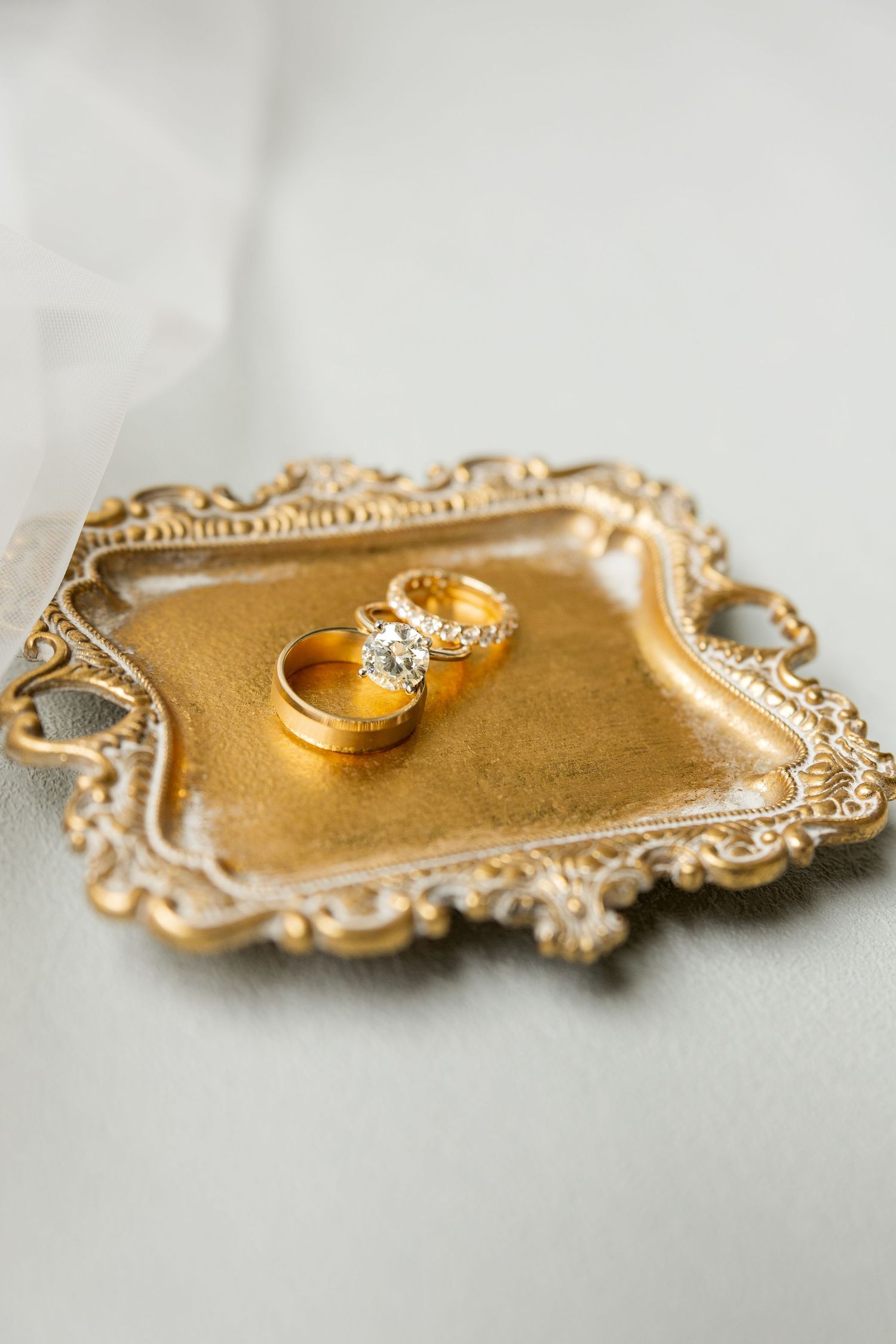 Gold vintage tray displays wedding rings with ornate decorative details.Cold Springs Events.