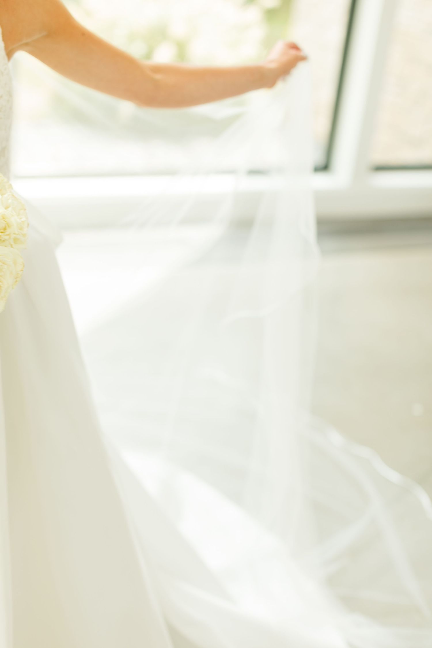 Ethereal close-up of flowing white wedding dress fabric in natural light.