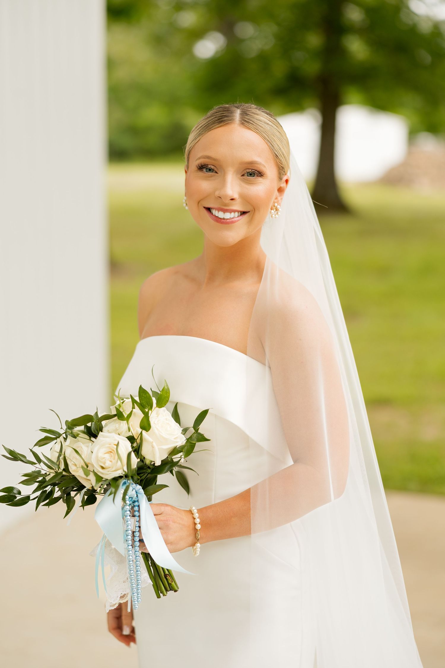 Bridal portraits with white and green bouquet against outdoor natural backdrop.Cold Springs Events