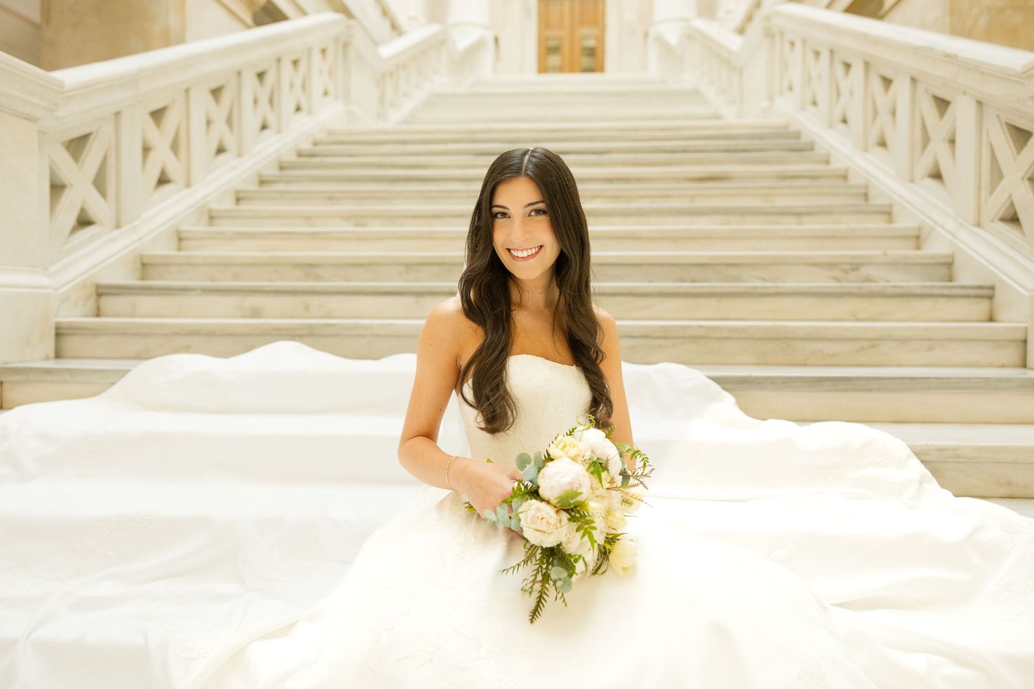 Bridal portraits showcasing a strapless wedding gown and bouquet on classic stone steps.