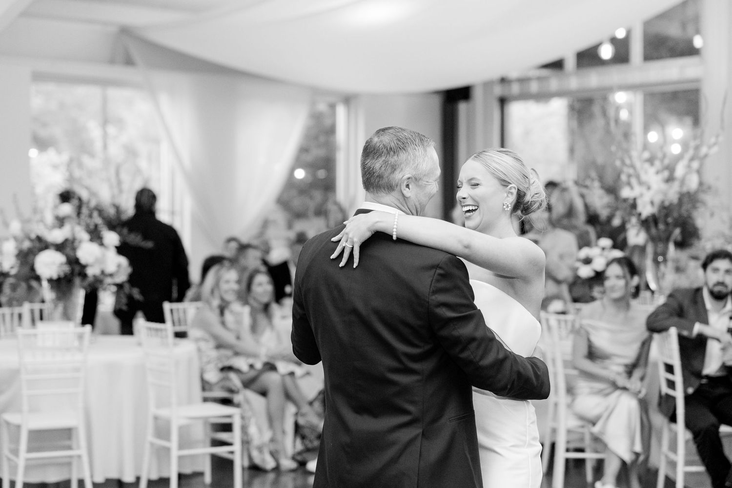 Elegant wedding reception setup with white tables and chairs in a bright indoor venue.Cold Springs Events